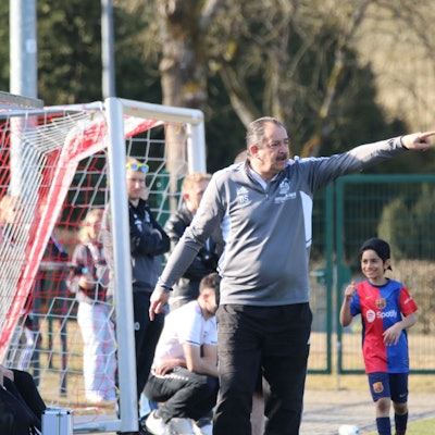 Das Bild zeigt Dirk Scheer am Spielfeldrand. Er gibt eine taktische Anweisung.