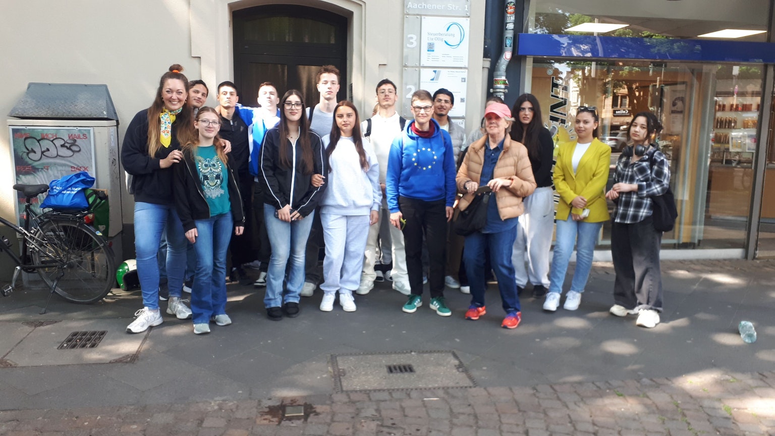 Sechs Menschen stehen vor einem Hauseingang.