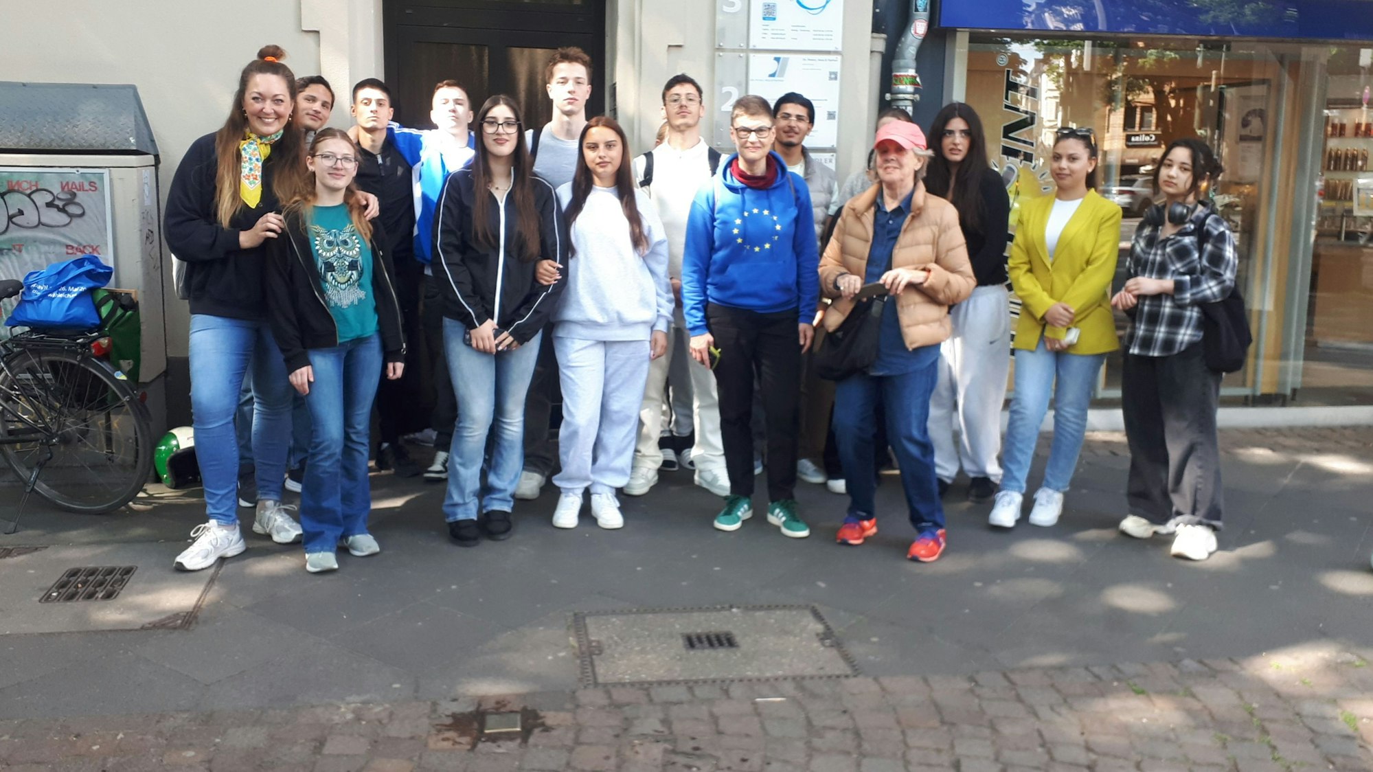 Sechs Menschen stehen vor einem Hauseingang.