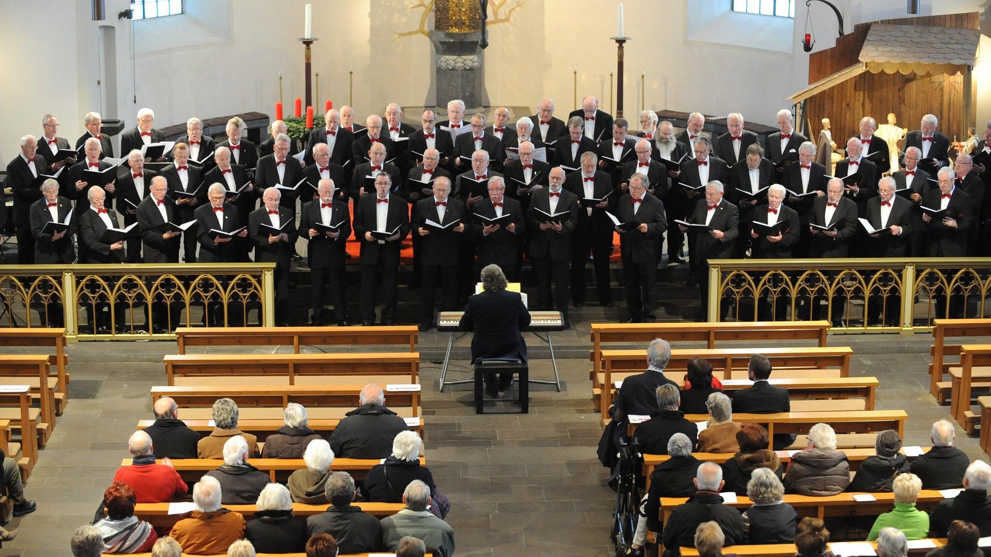 Ein Männerchor singt in einer Kirche.