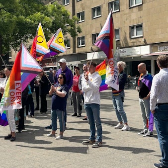 Demonstranten mit Regenbogen-Fahnen auf dem Friedrich-Ebert-Platz in Wiesdorf