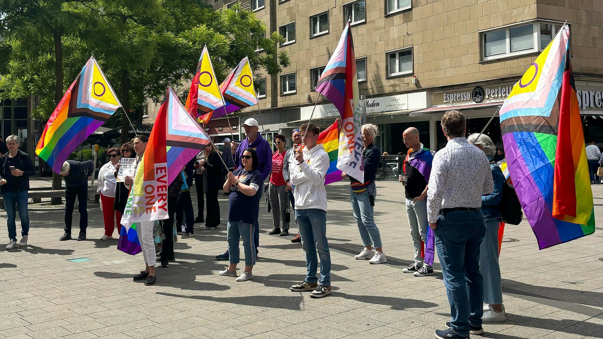Demonstranten mit Regenbogen-Fahnen auf dem Friedrich-Ebert-Platz in Wiesdorf