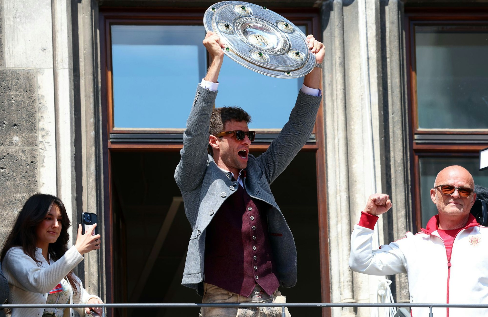 Thomas Müller jubelt mit der Meisterschale auf dem Rathausbalkon.