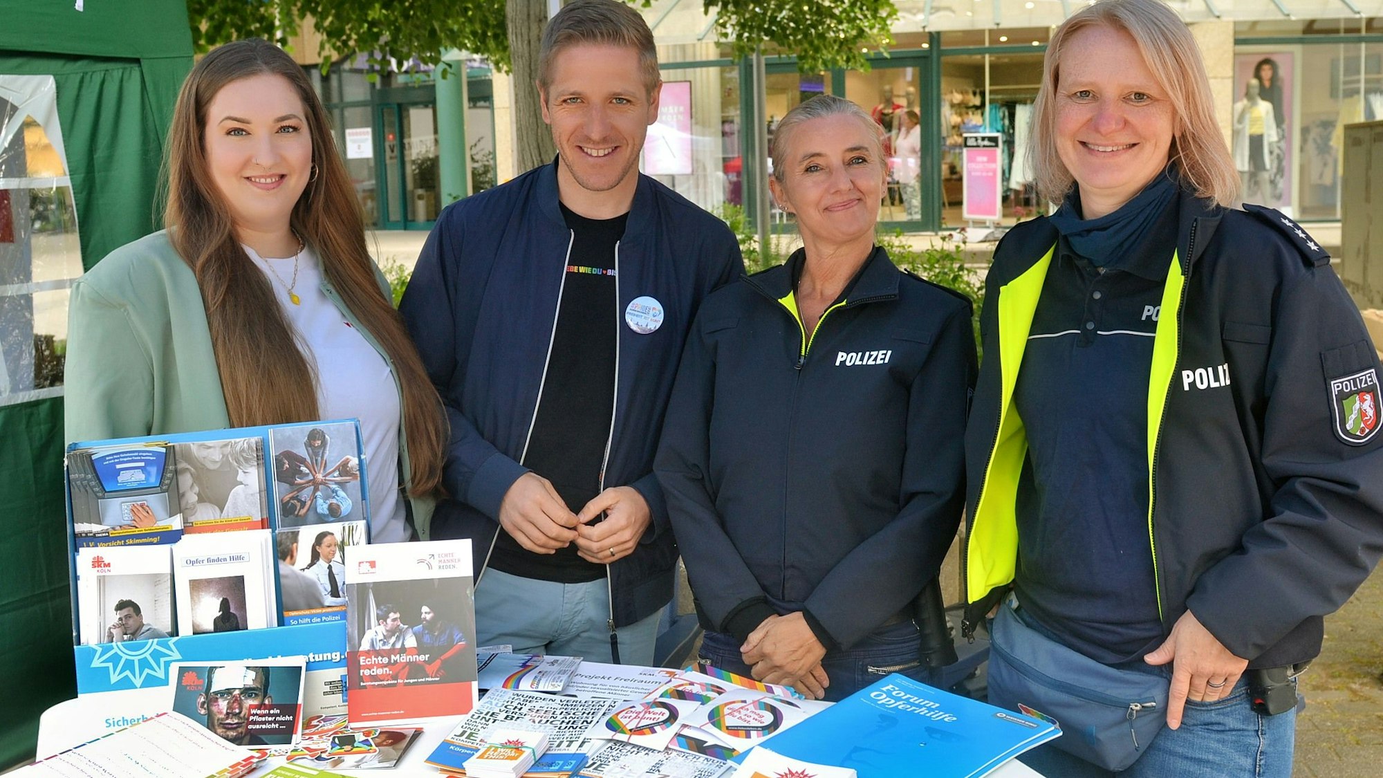 Nina Brömmelhaus, Markus Ramers, Eva Winkel und Yvonne Dederichs stehen hinter dem Infostand der Polizei.