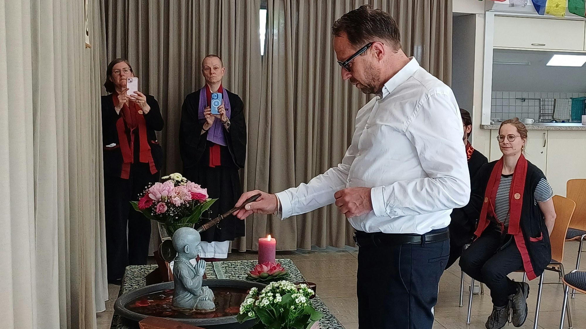 Oberbürgermeister Uwe Richrath vollzieht eine traditionellen Buddha-Waschung.