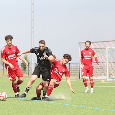 Das Bild zeigt zwei Fußballer im Kampf um den Ball.