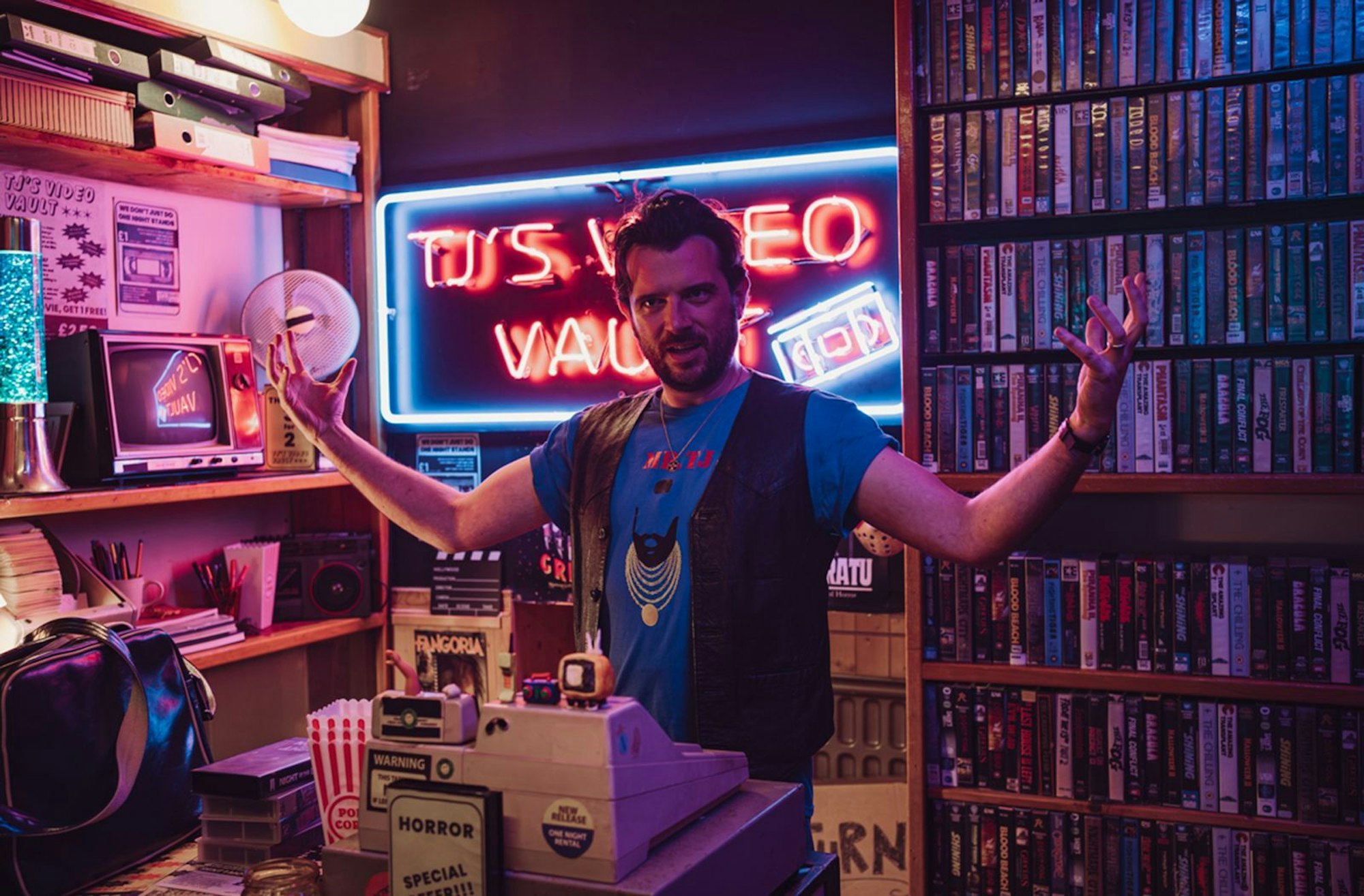 Der coole Meister der VHS-Welt. Videothekar TJ (Kevin McGahern) zeigt seine Sammlung. (Bild: © WDR/Deadpan Pictures/Madeline Mulqueen)