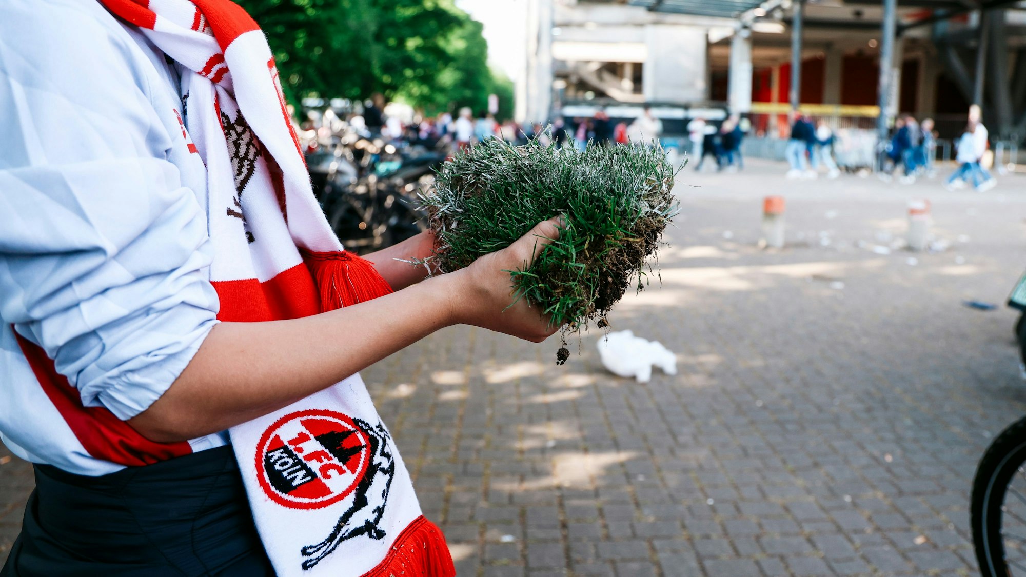 Eine Junge mit einem Stück Aufstiegs-Rasen vor dem Rhein-Energie-Station.