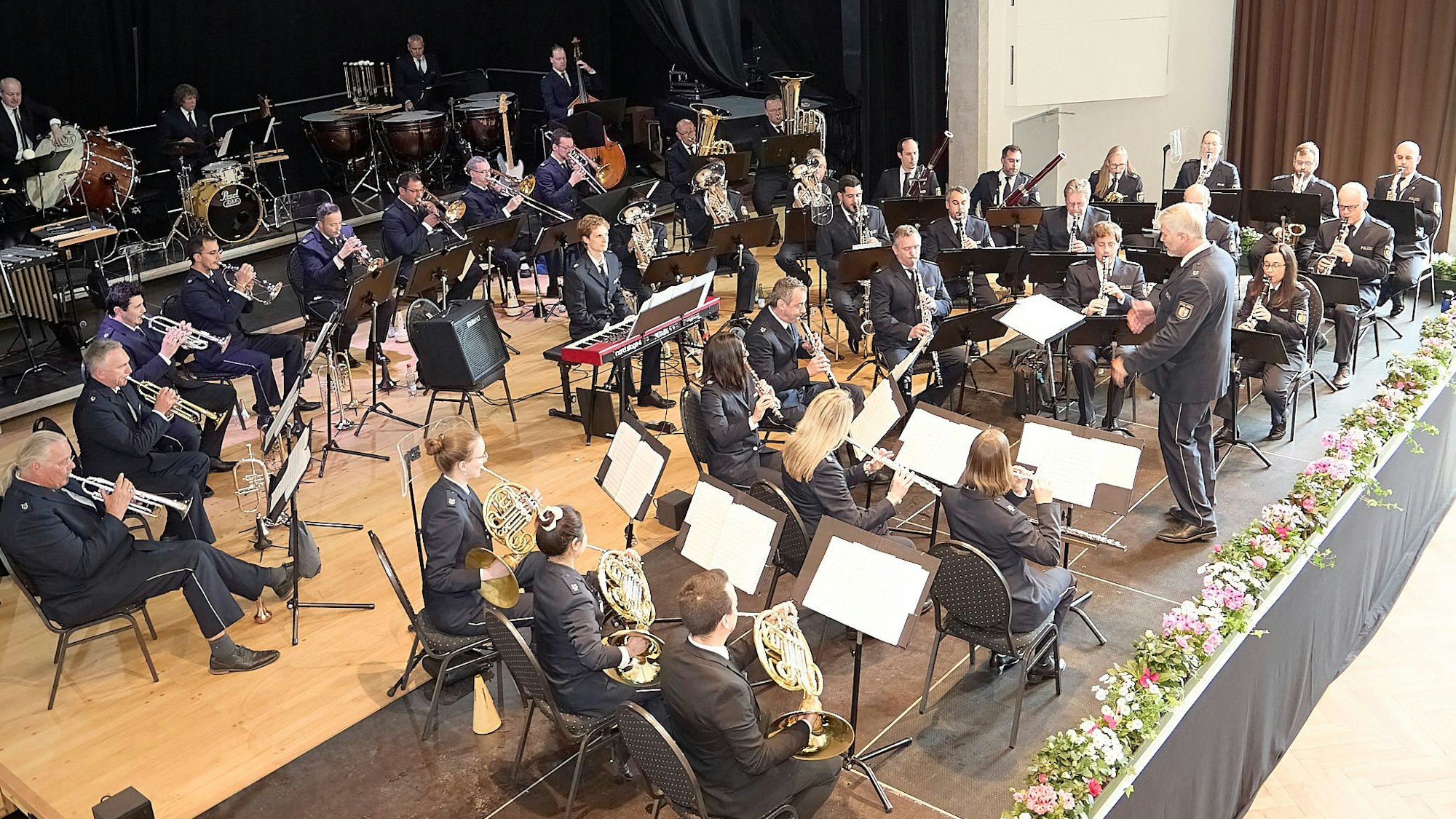 Die Musiker des Landespolizeiorchesters sitzen auf der Bühne im Kursaal in Gemünd und geben ein Konzert.
