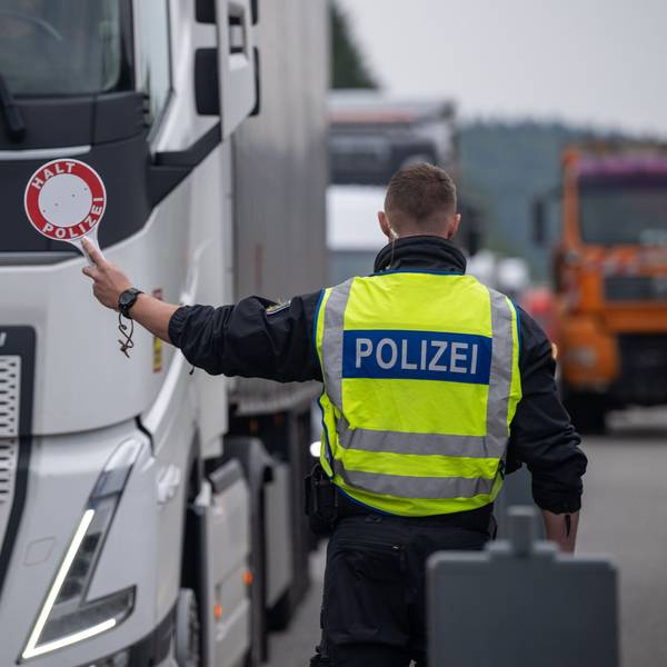 Polizisten kontrollieren Fahrzeuge zu Beginn der Grenzkontrollen an allen deutschen Landesgrenzen. Ein Polizist in Warnweste hält eine Kelle auf der „Halt Polizei“ steht, in Richtung eines LKW. (Archivbild)