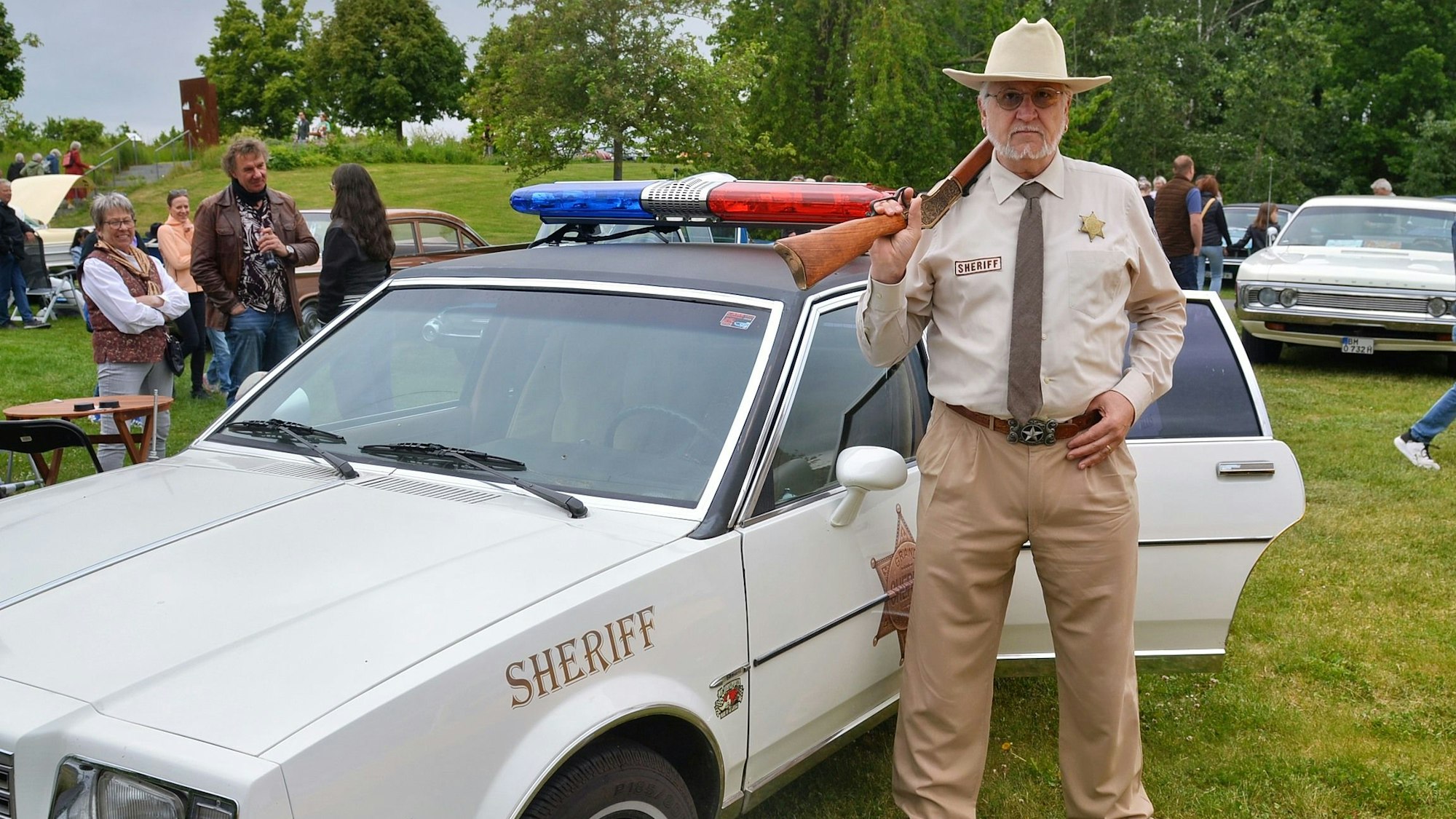 In der Rolle eines US-amerikanischen Sheriffs präsentiert sich Backermann: in Uniform, mit Sheriffstern und einer Gewehr-Attrappe.