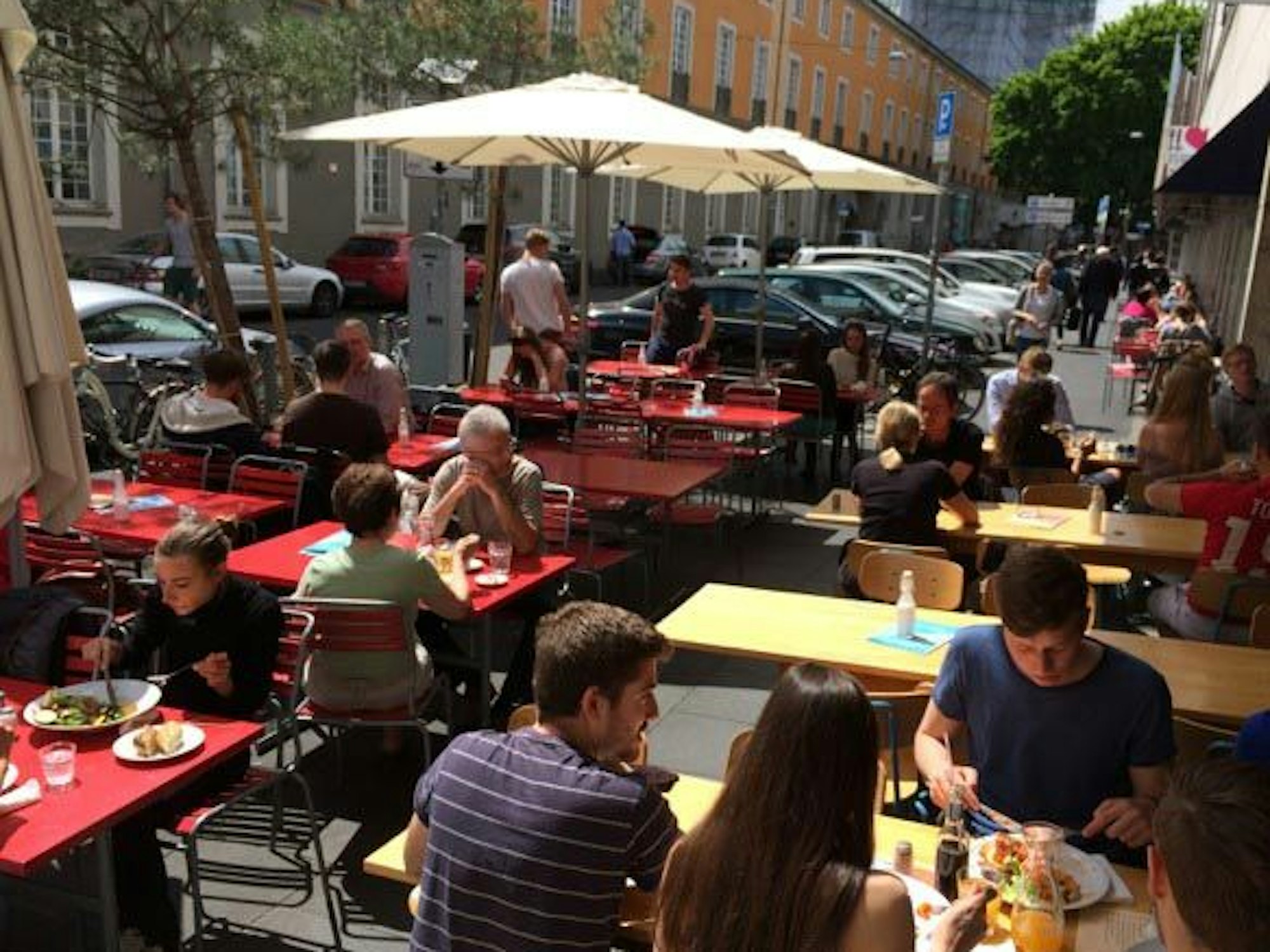 Auch vor dem Café Blau konnten Gäste an zahlreichen Tischen Platz nehmen. Im Hintergrund das historische Gebäude der Uni Bonn.