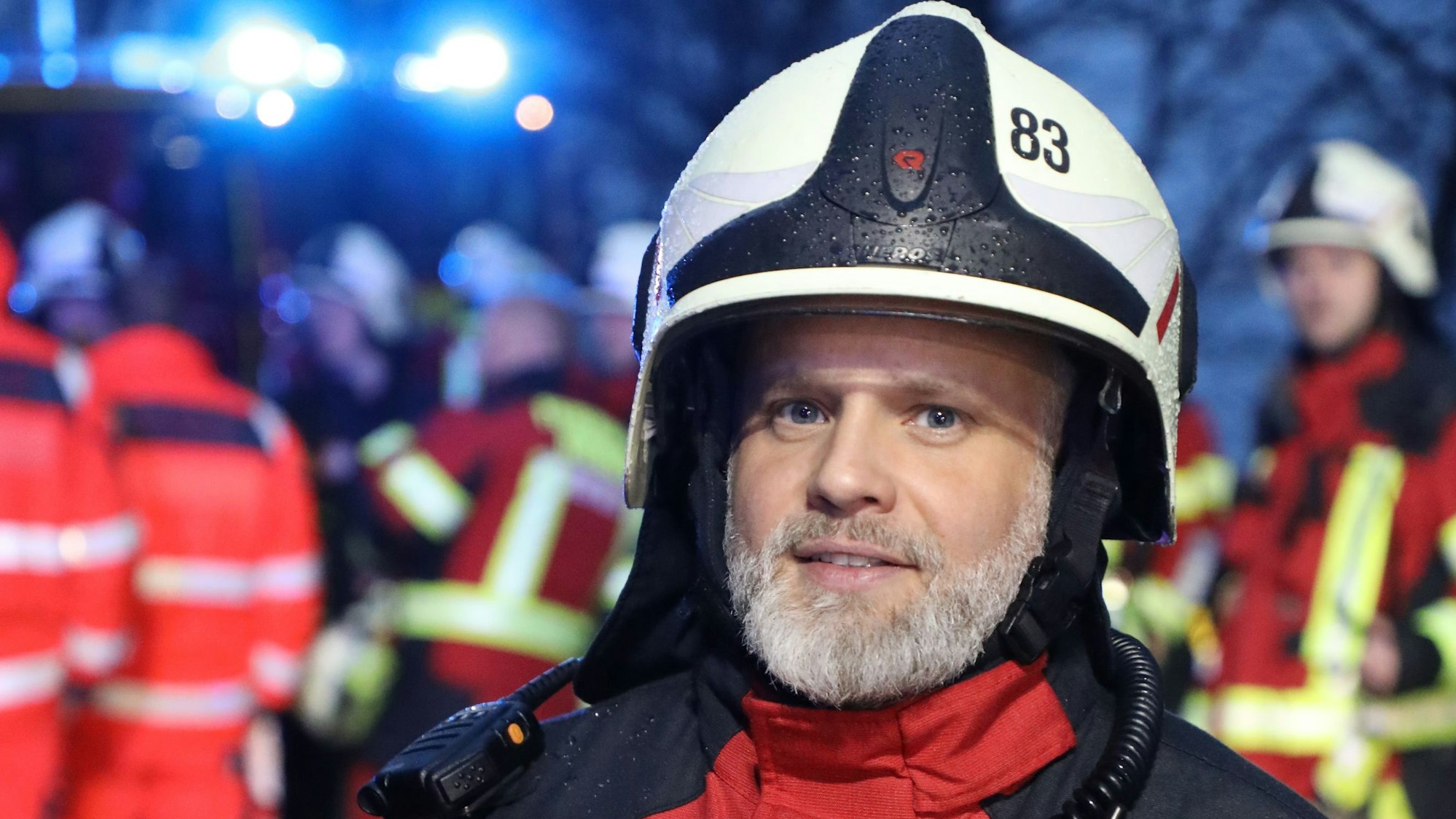 Overaths Feuerwehrsprecher Marco Bücheler in Einsatzkleidung schaut in die Kamera.