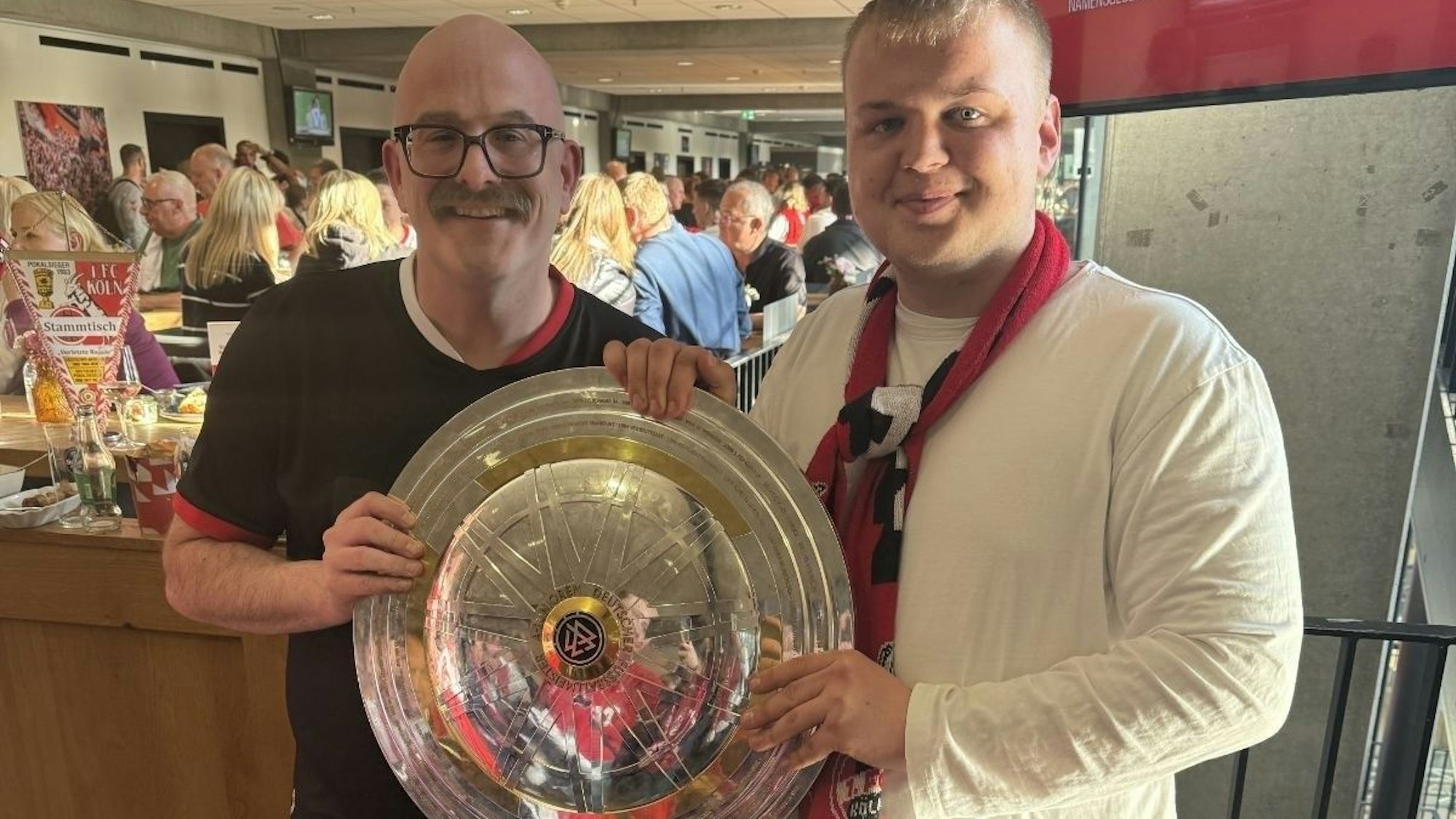 Das Bild zeigt Dominik Schmitz mit Philipp Teitge. Beiden halten die Meisterschale in den Händen.