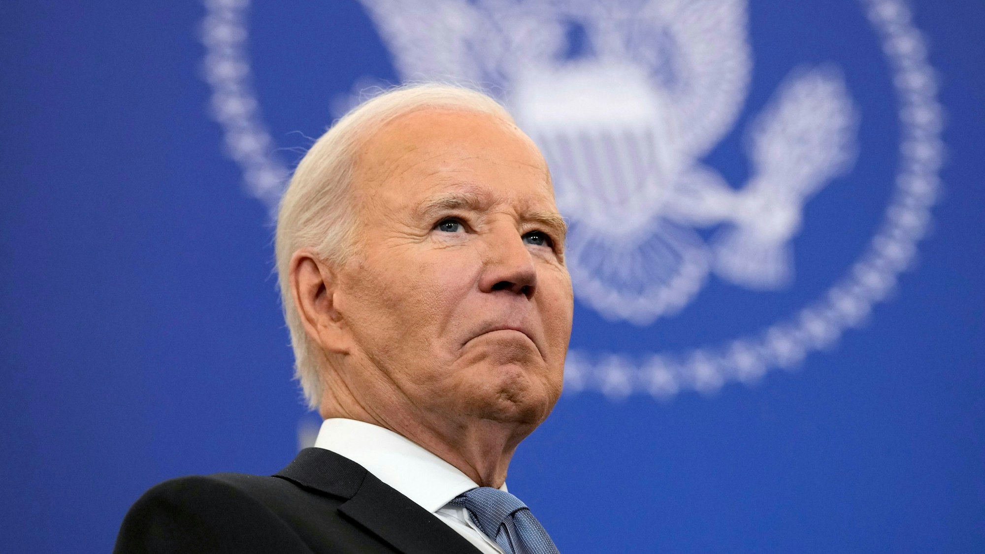 Joe Biden ist von schräg unten fotografiert. Er schaut in die Ferne.