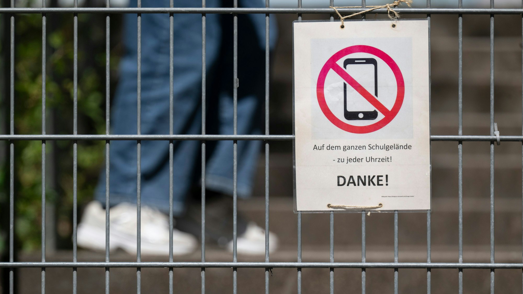 Ein Schild mit einem durchgestrichenen Smartphone und der Aufschrift «Auf dem ganzen Schulgelände - zu jeder Uhrzeit! DANKE!»