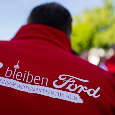 Ein Mitarbeiter trägt eine Jacke mit der Aufschrift „Wir bleiben Ford - Gemeinsam weiterkämpfen für Köln“ bei einem Streik in den Kölner Ford-Werken. Mittlerweile sind weitere Streiks vorerst vom Tisch: Management und Betriebsräte haben sich auf Eckpunkte geeinigt, die aber noch von der Konzernzentrale in den USA genehmigt werden müssen