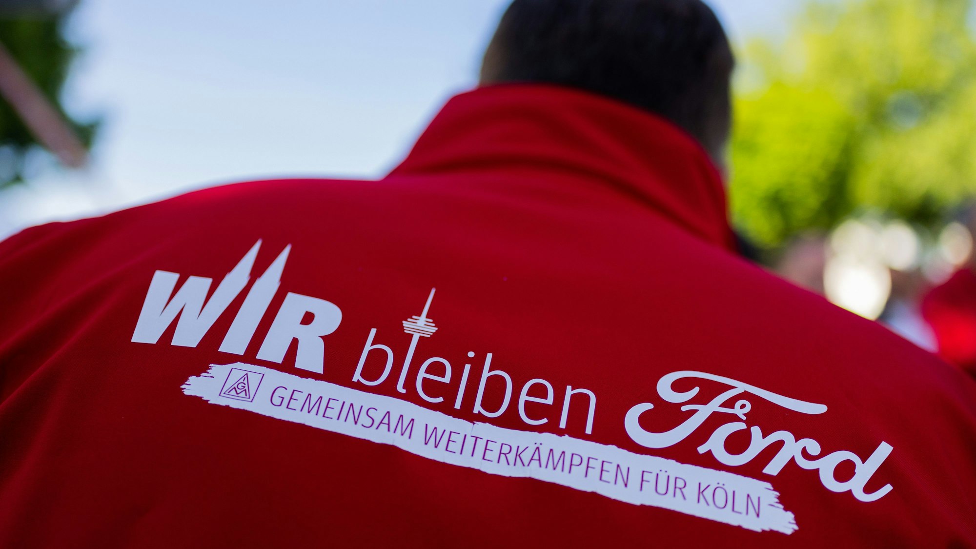 Ein Mitarbeiter trägt eine Jacke mit der Aufschrift „Wir bleiben Ford - Gemeinsam weiterkämpfen für Köln“ bei einem Streik in den Kölner Ford-Werken. Mittlerweile sind weitere Streiks vorerst vom Tisch: Management und Betriebsräte haben sich auf Eckpunkte geeinigt, die aber noch von der Konzernzentrale in den USA genehmigt werden müssen
