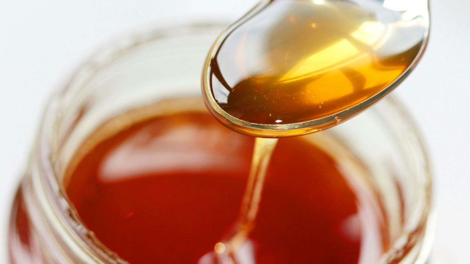 Ein Löffel in einem Honigglas.