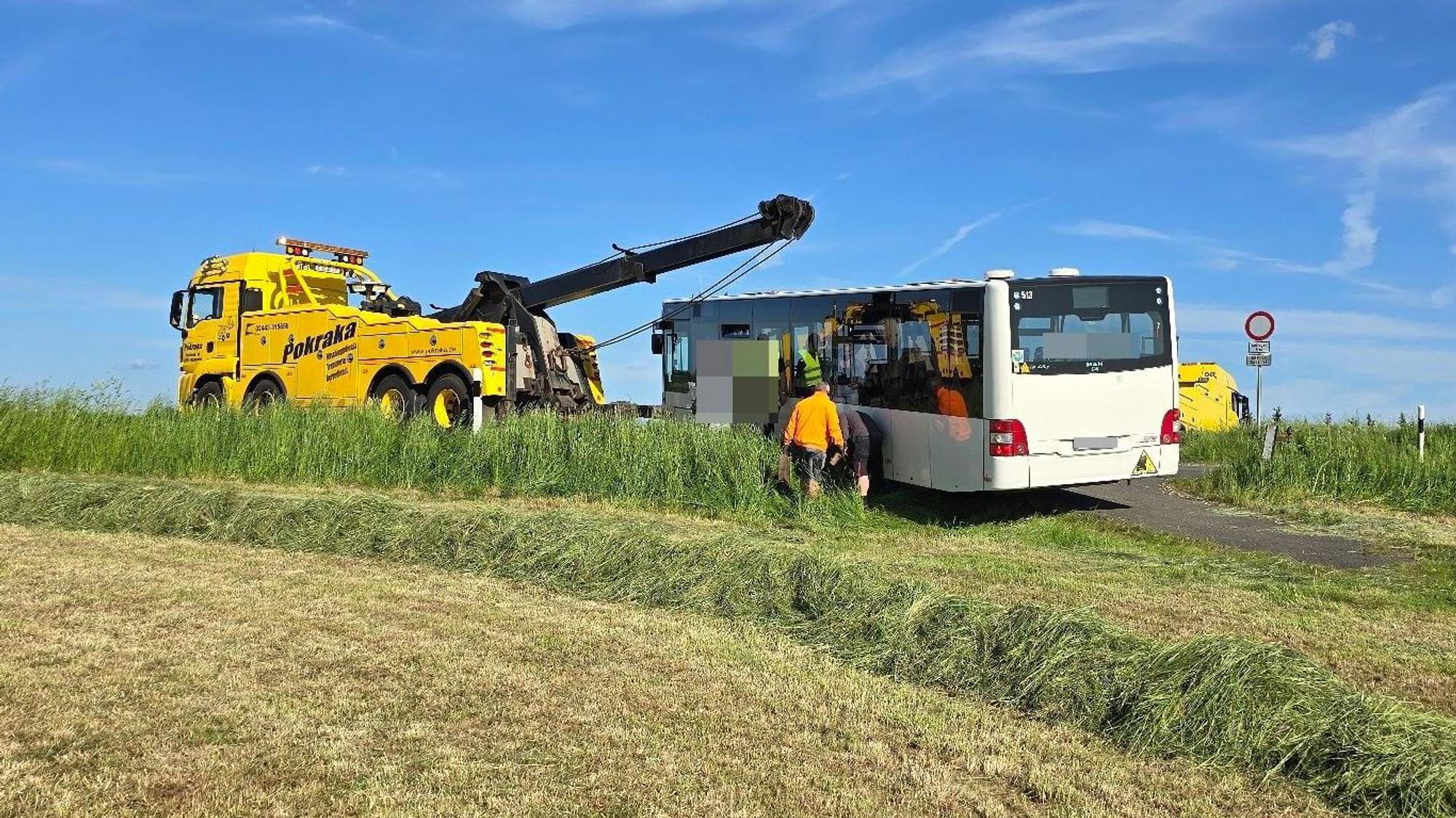 Ein Abschleppwagen steht vor dem Bus, der mit einem Stahlseil gezogen wird.