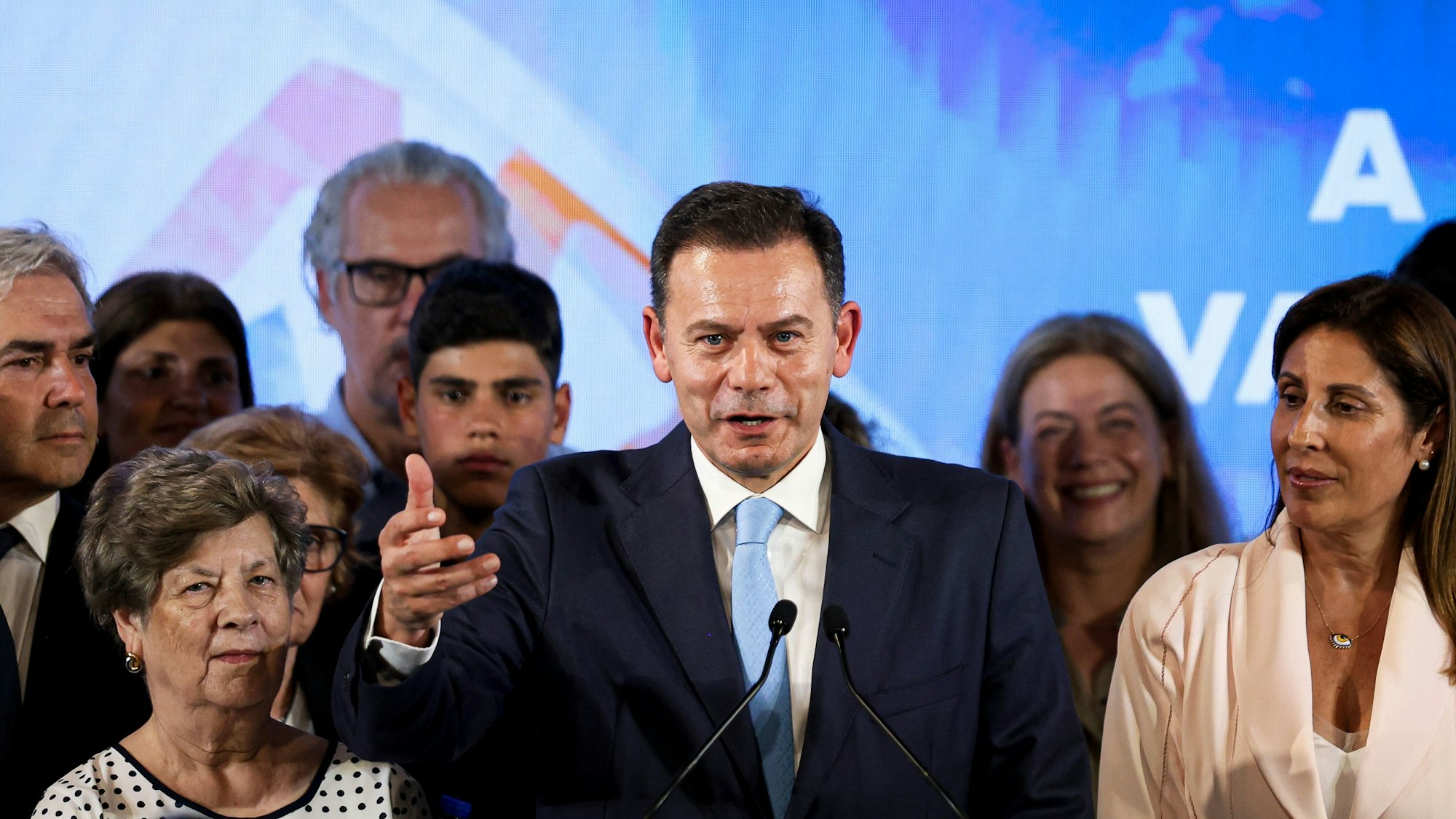 Luis Montenegro, flankiert von Mutter und Ehefrau, hält eine Rede.