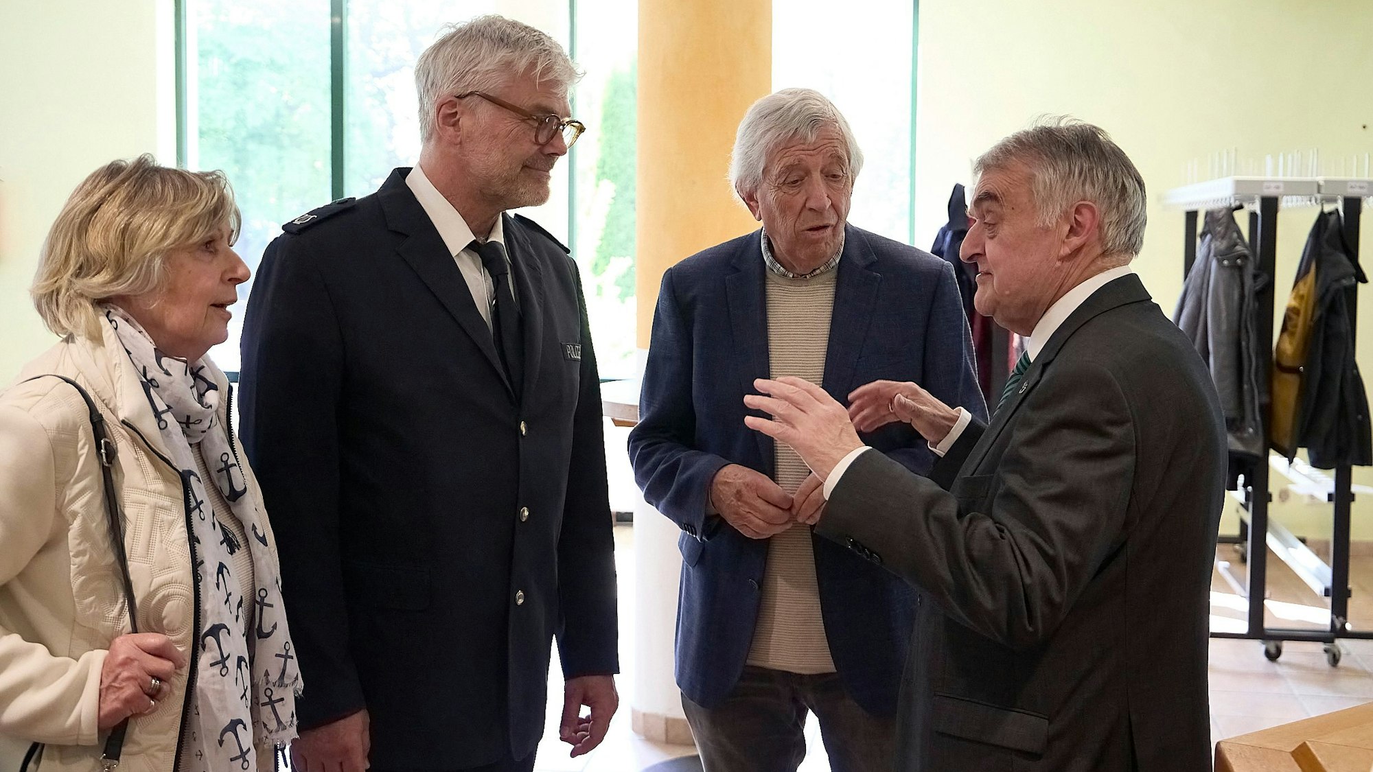 Im Foyer des Kurhauses in Gemünd unterhalten sich drei Männer und eine Frau. Rechts ist NRW-Innenminister Herbert Reul zu sehen.