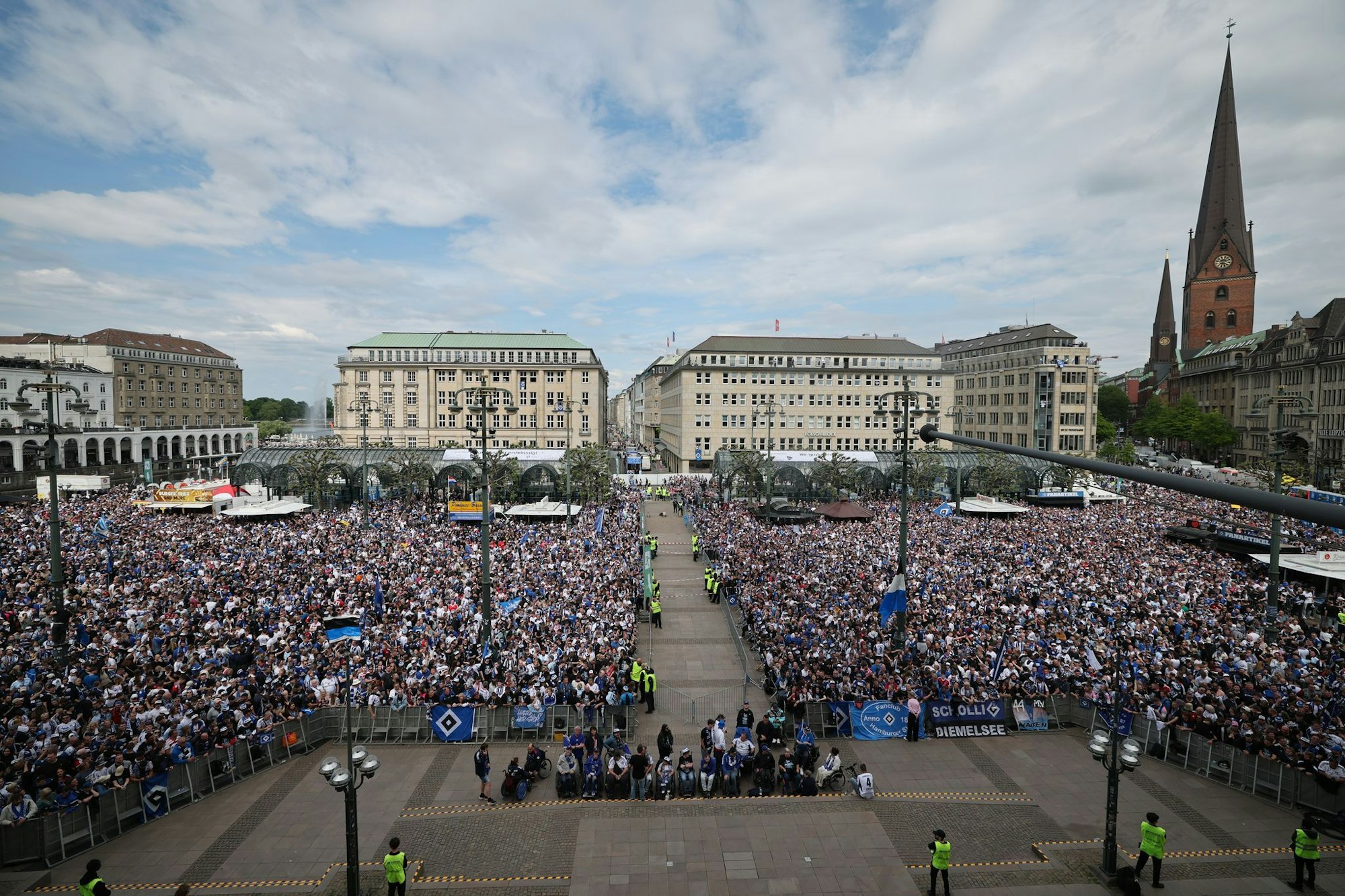 HSV-Fans stehen auf dem Rathausmarkt vor dem Hamburger Rathaus und feiern ihren Club.