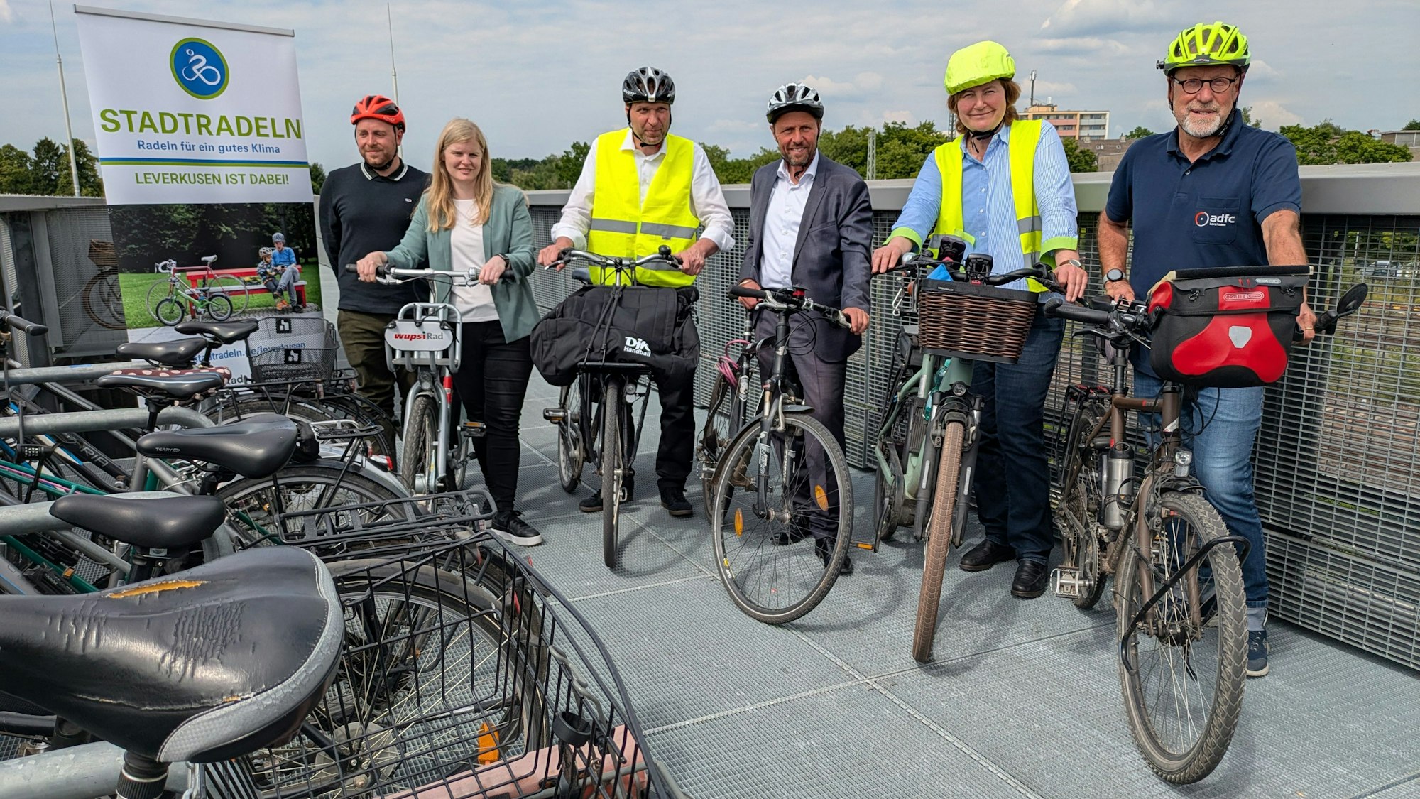 Männer und Frauen stehen mit Rädern auf dem Dach des Fahrradparkhauses in Opladen.