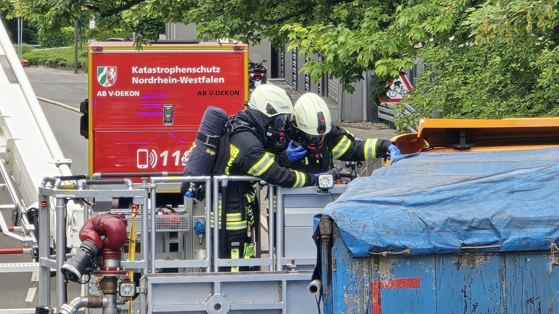 Zwei Feuerwehrleute untersuchen die Ladefläche eines Lkw.