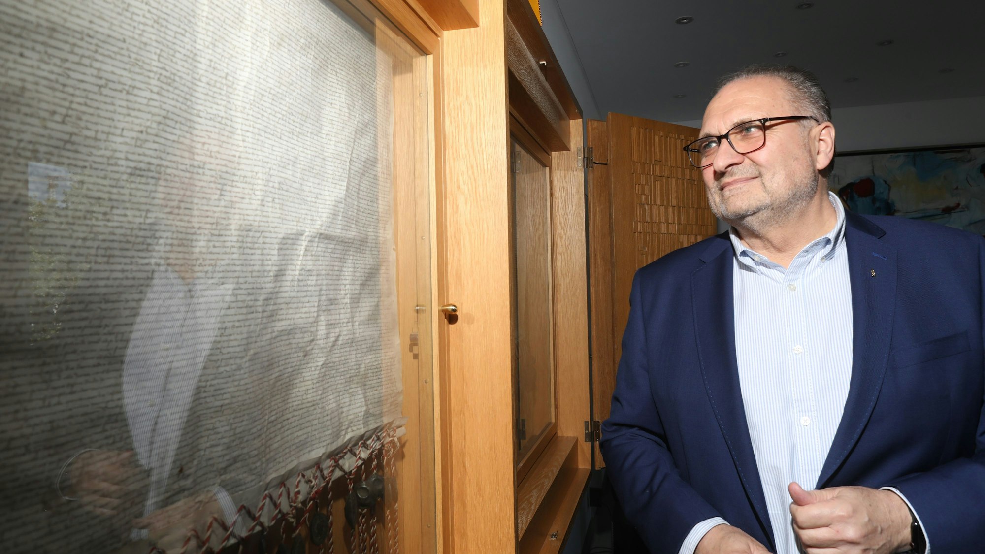 Handwerkskammer-Präsident Hans Peter Wollseifer in seinem Büro neben der „Ersten Kölner Stadtverordnung“, die mehr als 600 Jahre alt ist