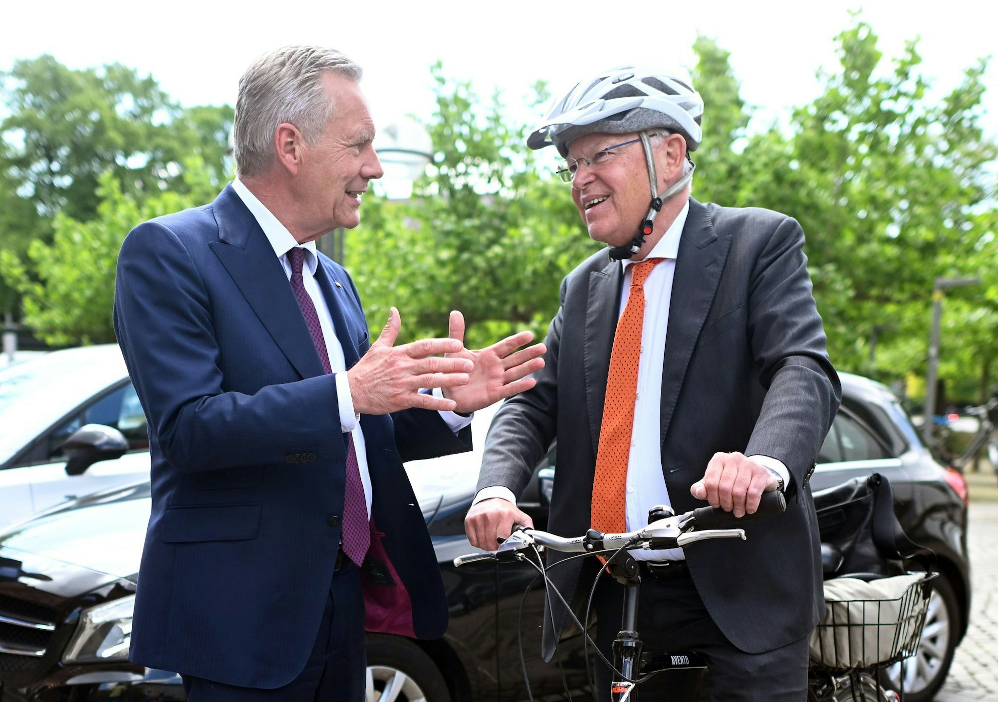 Mit Helm und Fahrrad kommt Stephan Weil (r) zur Wahl, bei der auch Christian Wulff zu Gast ist.