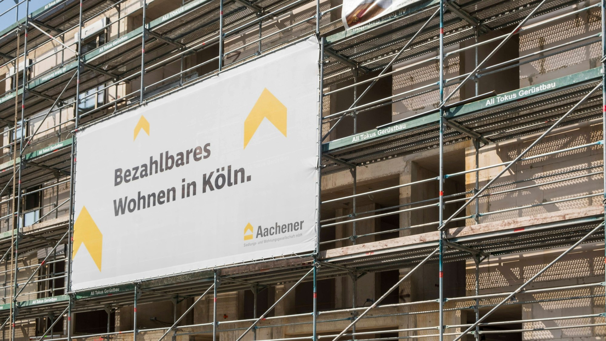 Ehemalige Clouth Werke in Köln-Nippes. Baustelle an der Wohnungen entstehen mit Baugerüst an dem ein Banner hängt, das darauf hinweist, dass die Wohnungen öffentlich gefördert sind. *** Former Clouth works in Cologne-Nippes. Construction site where flats are being built with scaffolding on which a banner hangs indicating that the flats are publicly funded. Nordrhein-Westfalen Deutschland, Germany GMS9285