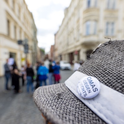 „Omas gegen Rechts“ steht auf einem Anstecker, der am Hut einer Teilnehmerin einer Kundgebung für ein AfD-Verbot teilnimmt.