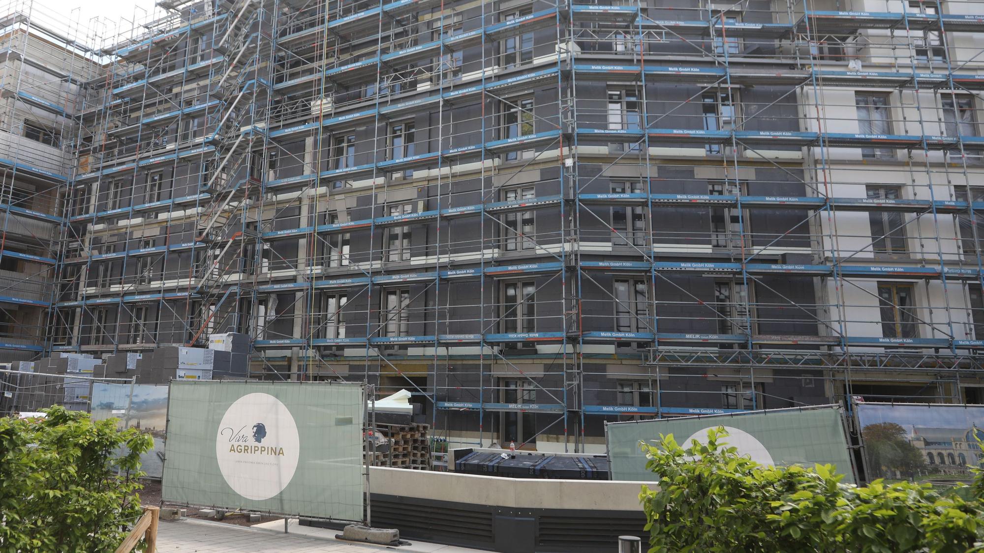 Zu sehen ist eine Hausfassade, die größtenteils von Baugerüsten bedeckt ist.