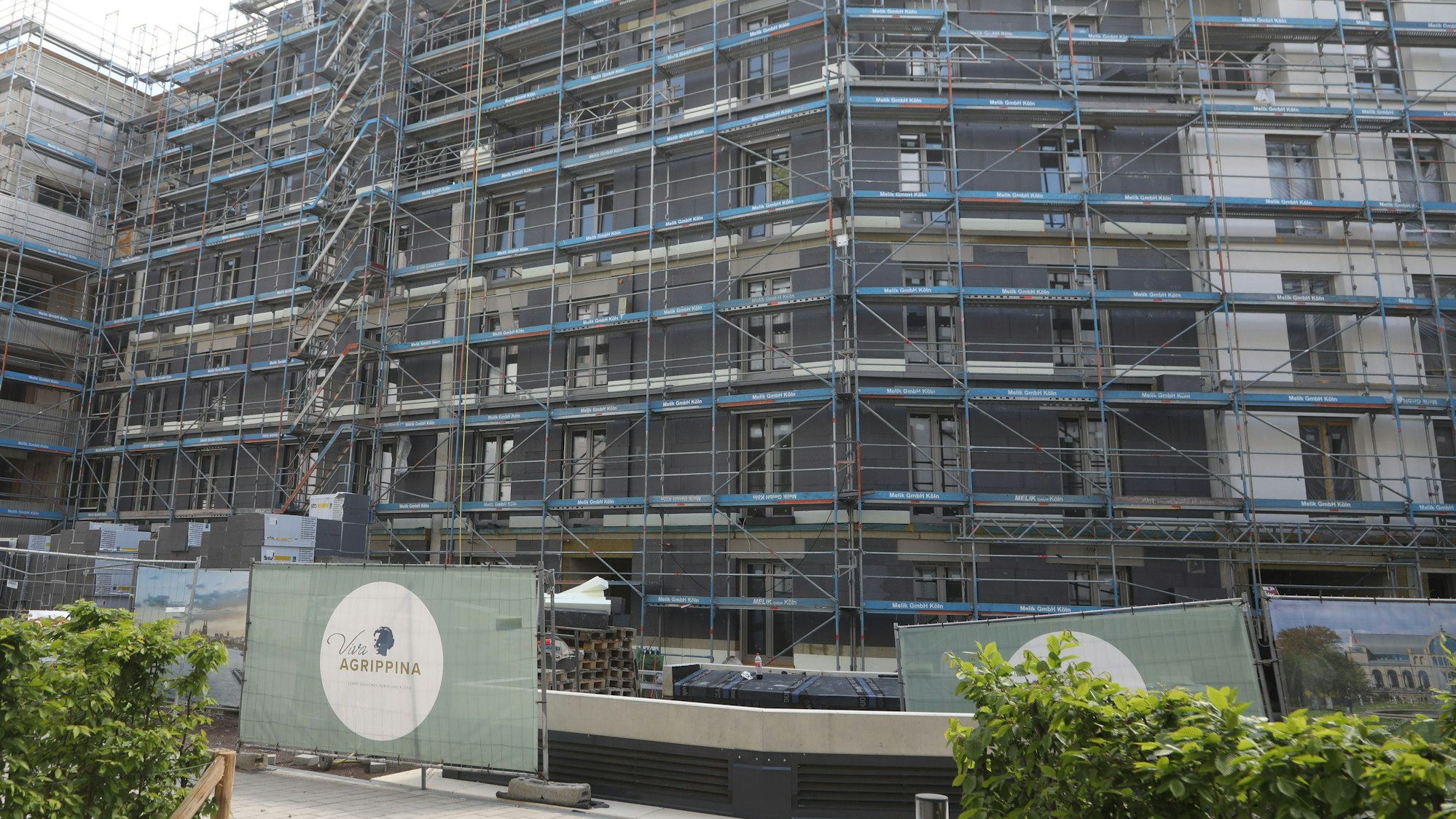 Zu sehen ist eine Hausfassade, die größtenteils von Baugerüsten bedeckt ist.