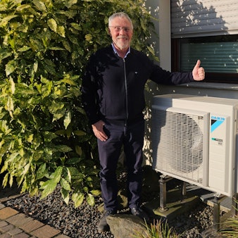 Zu sehen ist Günter Molt, der neben seiner Wärmepumpe steht.