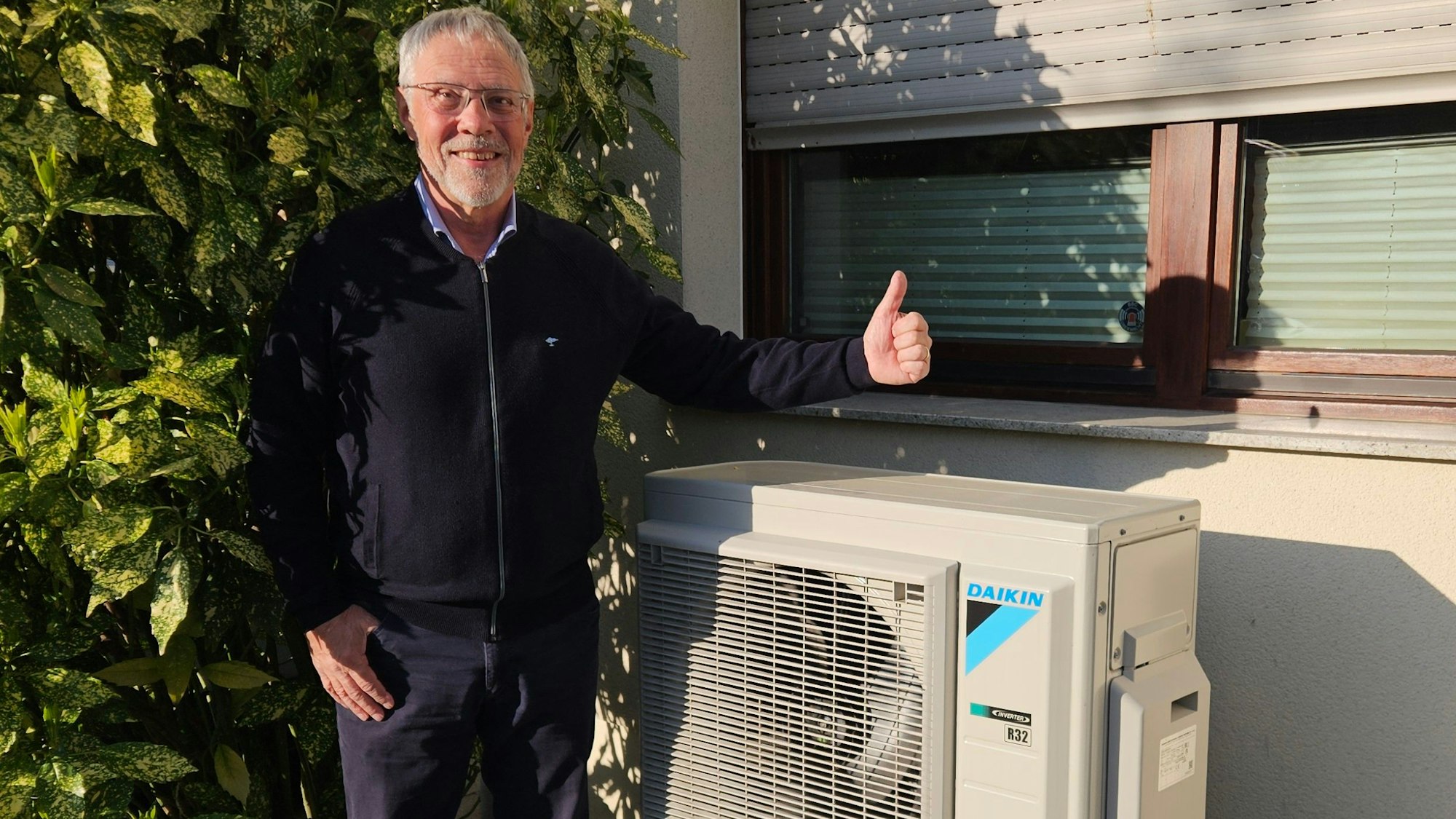 Zu sehen ist Günter Molt, der neben seiner Wärmepumpe steht.