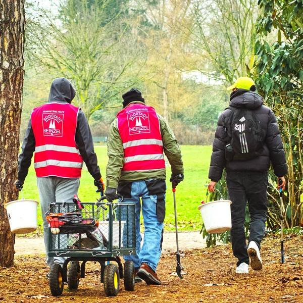 Drei Männer im Volksgarten sammeln Müll