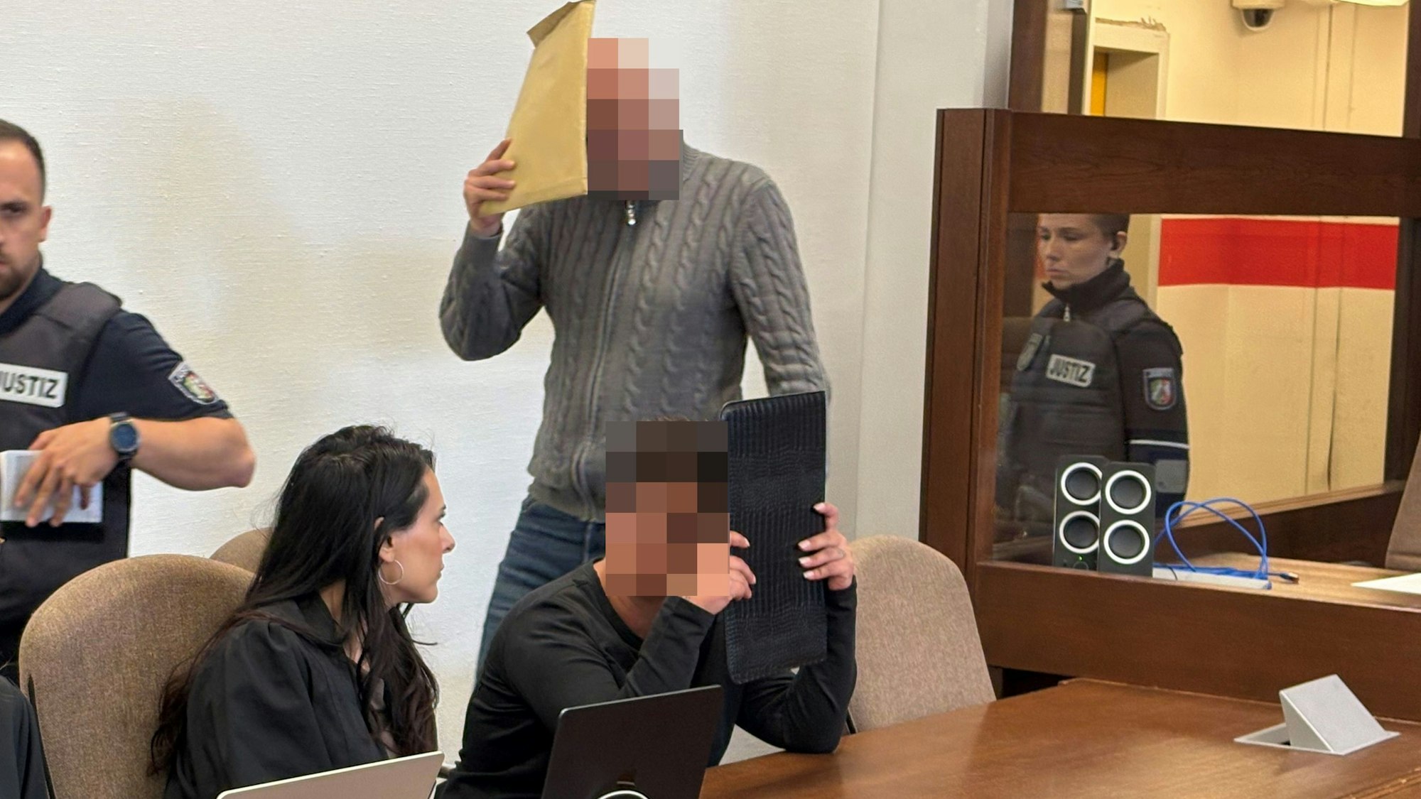 Die Angeklagten mit Verteidigerin Pantea Farahzadi beim Prozessauftakt im Kölner Landgericht