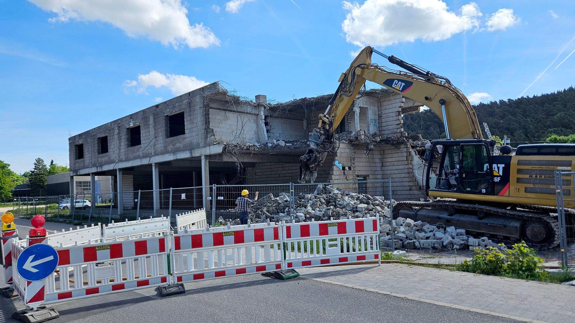 Das Foto zeigt einen Bagger beim Abbruch des Gebäudes.