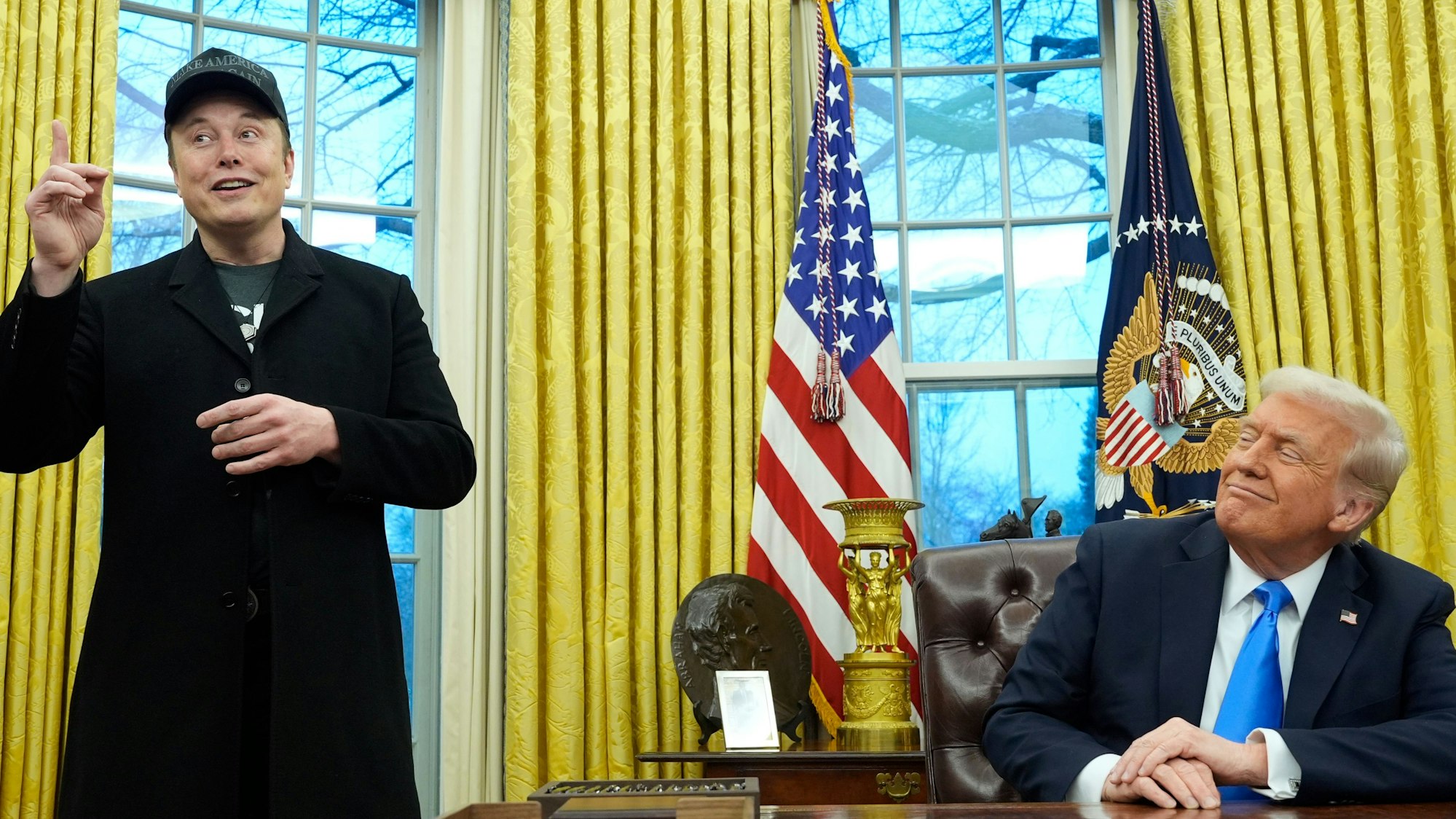 US-Präsident Donald Trump (r) hört zu, als Elon Musk im Oval Office im Weißen Haus spricht.