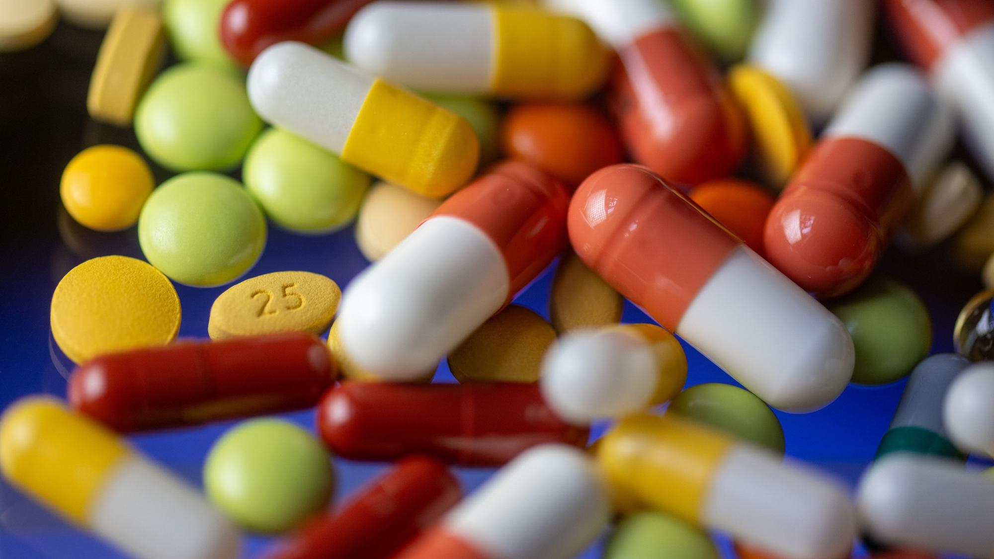 Verschiedene Tabletten, Kapseln und Dragees liegen auf einem Tisch.