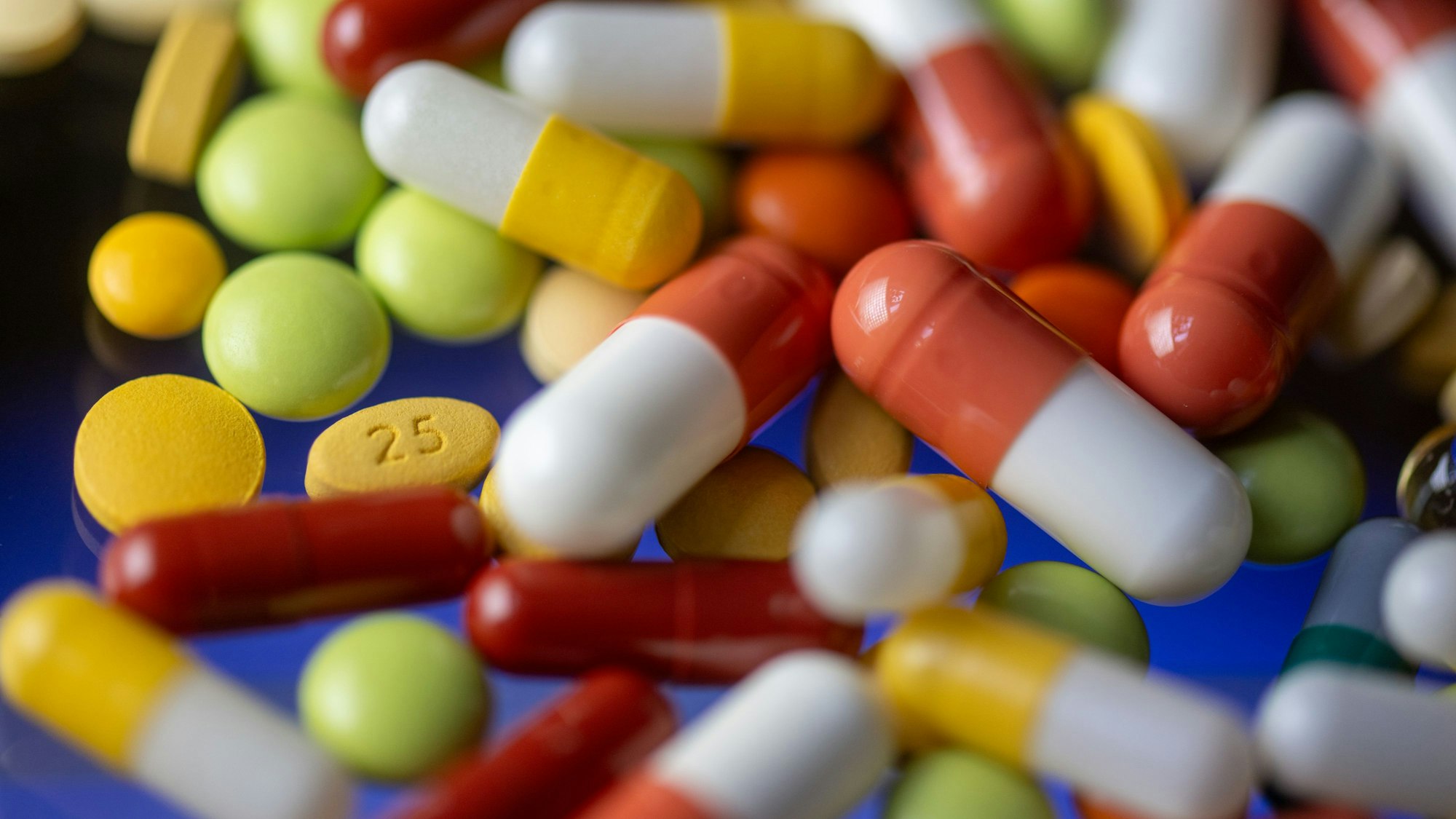 Verschiedene Tabletten, Kapseln und Dragees liegen auf einem Tisch.