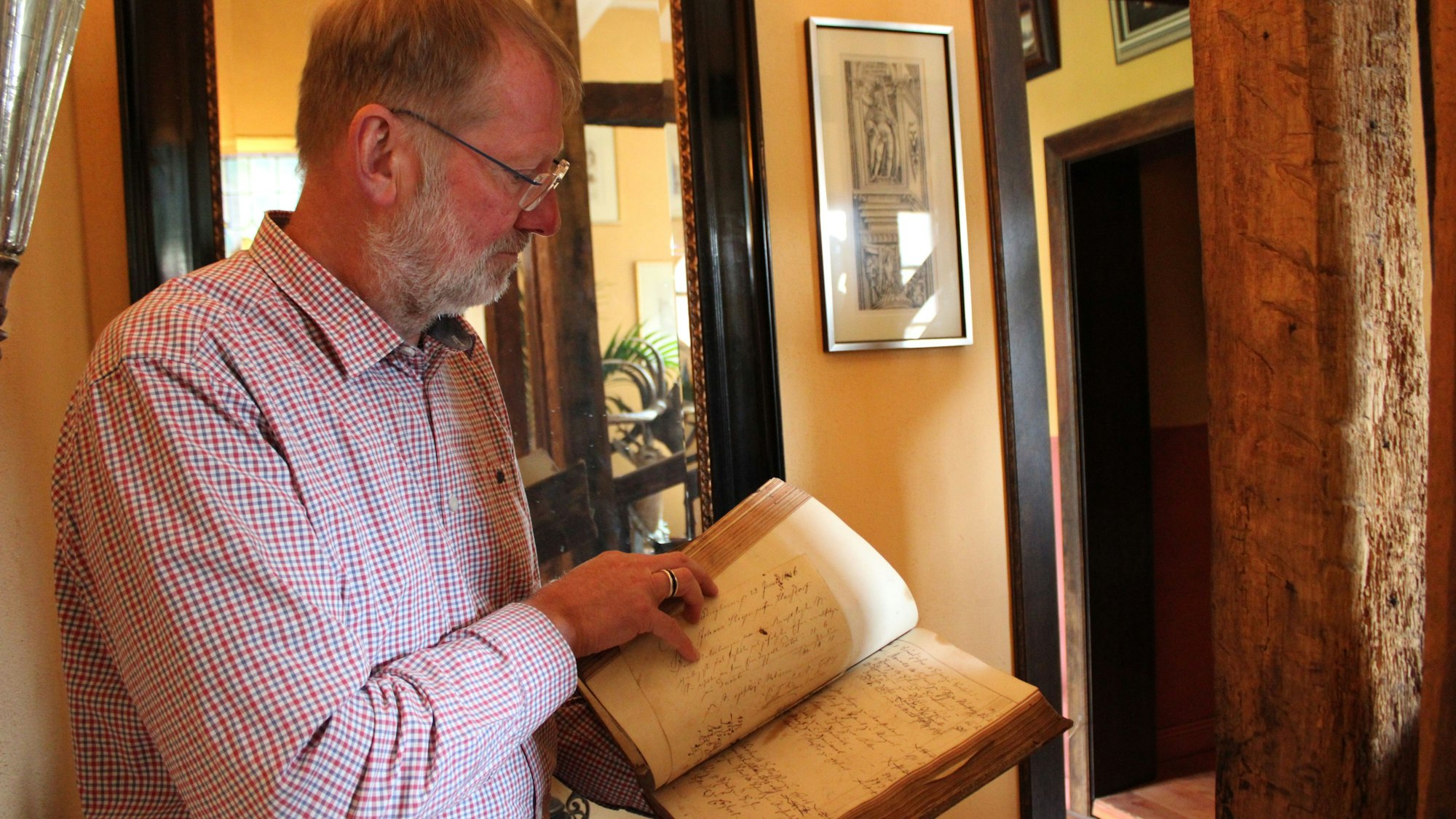 Gerd Melchior mit einem alten „Hammerbuch“ aus dem Haus Dorp, in dem hier noch zu Mittelalterzeiten Einnahmen und Ausgaben festgehalten wurden.