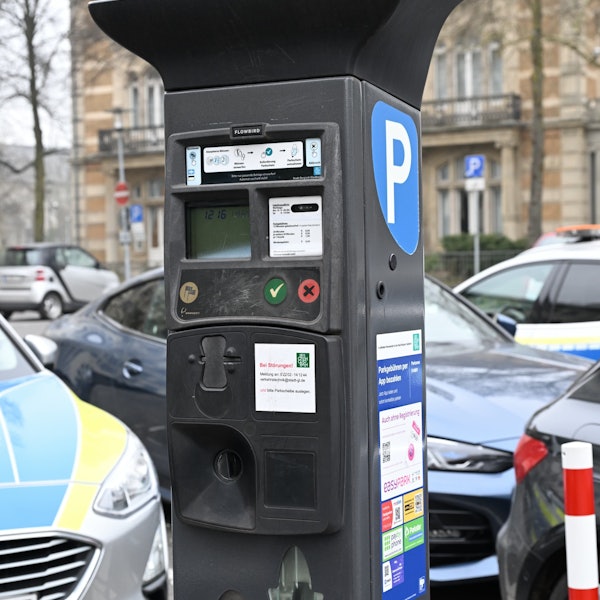 Ein klassischer Automat mit Münzfach steht am Straßenrand.