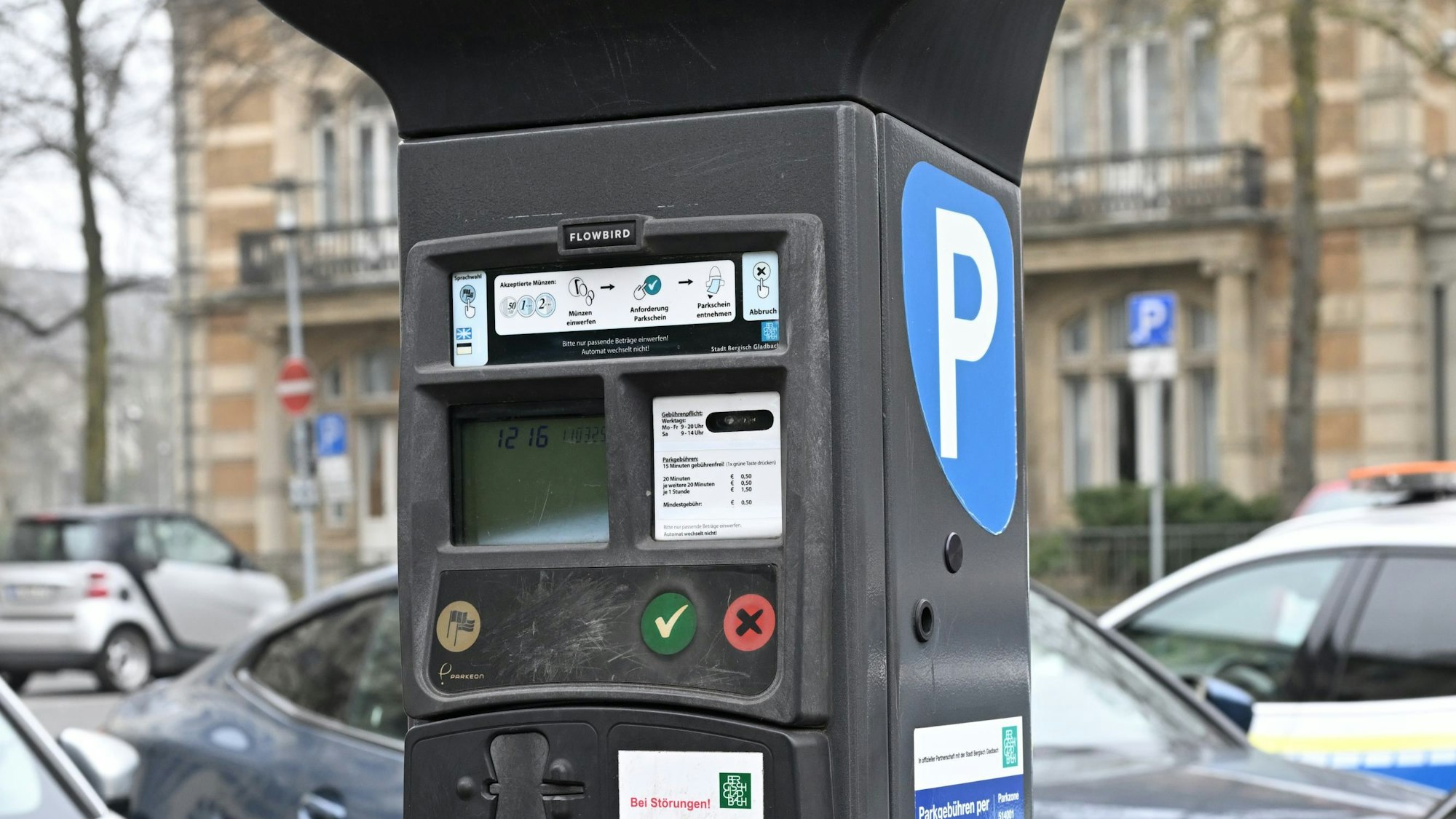 Ein klassischer Automat mit Münzfach steht am Straßenrand.