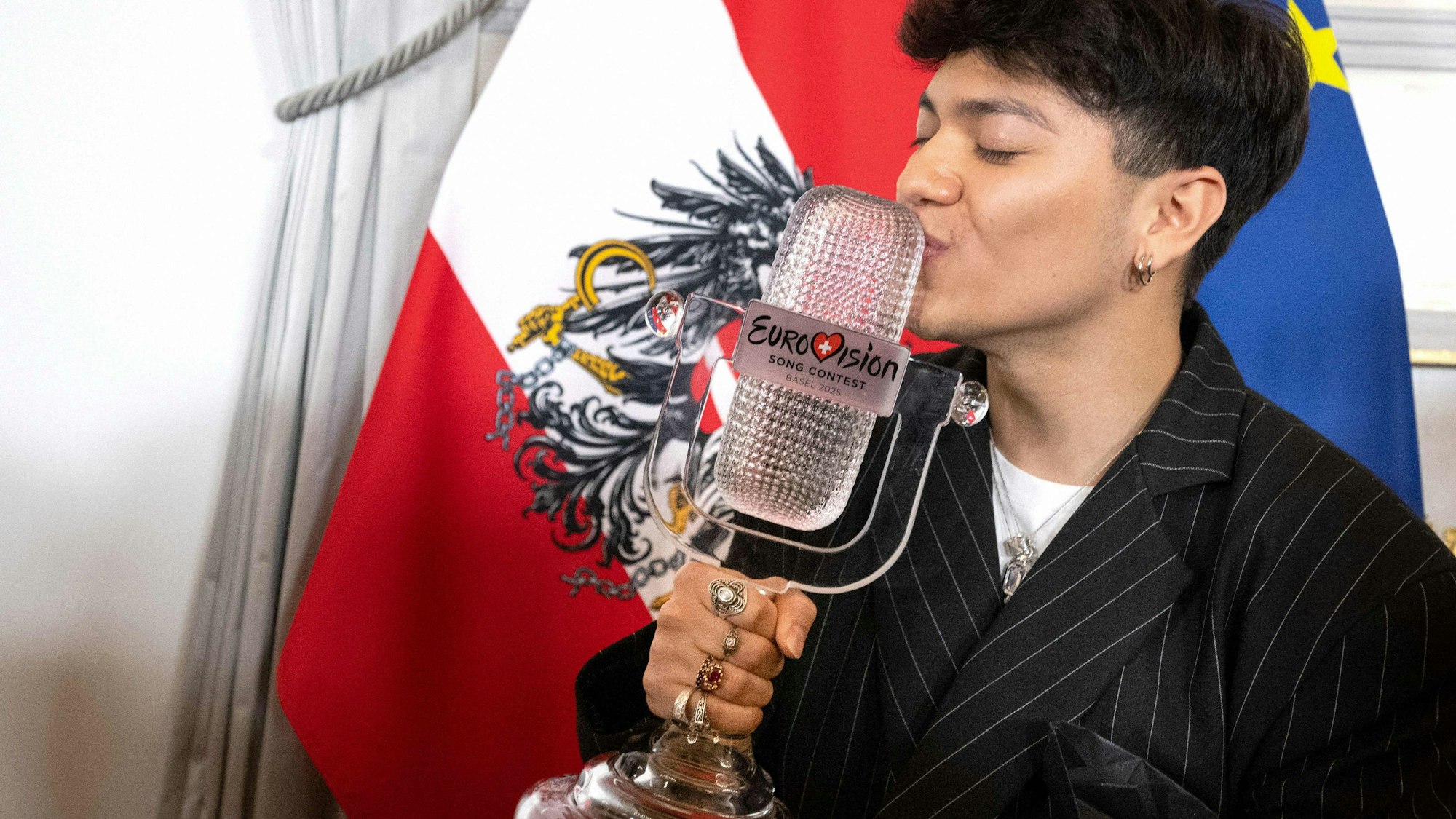 Der österreichische Sänger Johannes Pietsch alias JJ, Gewinner des Eurovision Song Contest 2025, posiert mit seiner Trophäe nach einer Pressekonferenz im Bundeskanzleramt in Wien.