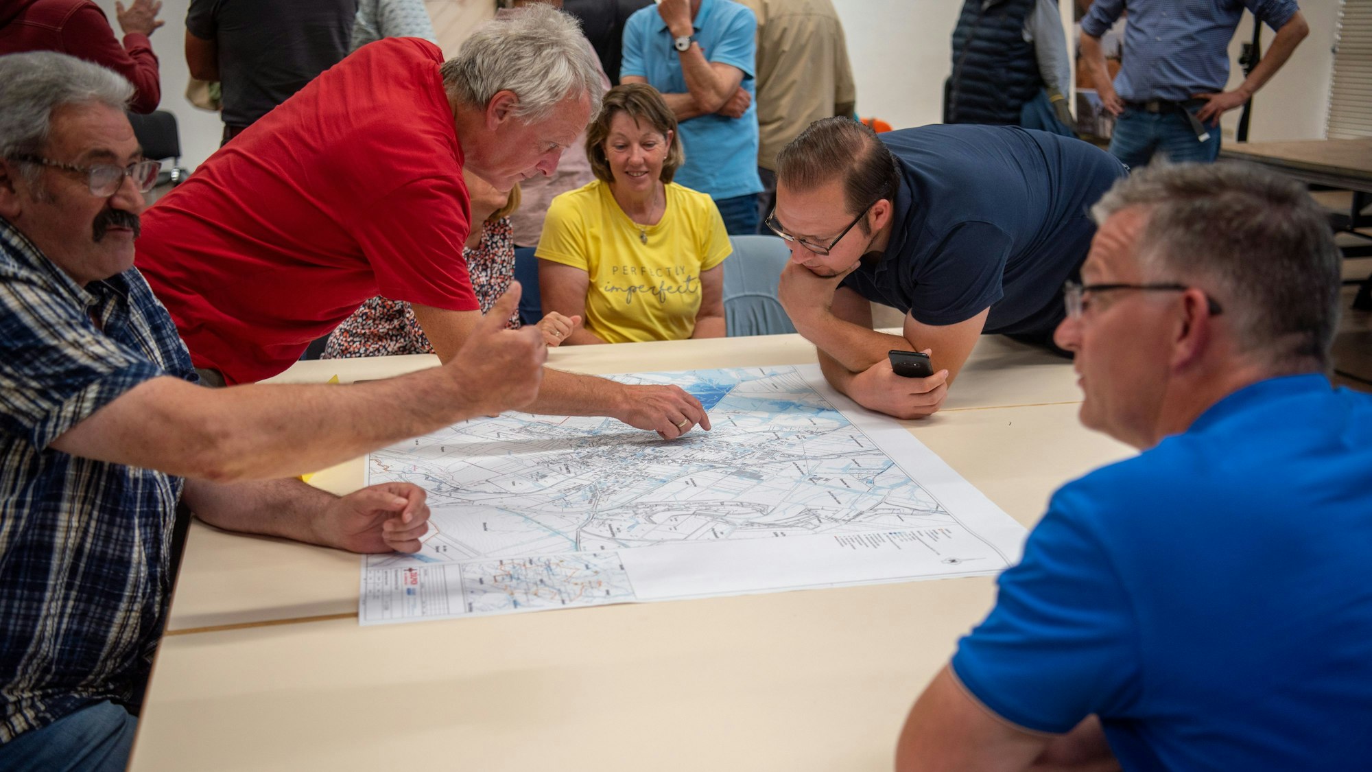 Anwohner aus Schwerfen diskutieren beim Bürgerworkshop zum Hochwasserschutzkonzept über Hochwasserkarten.