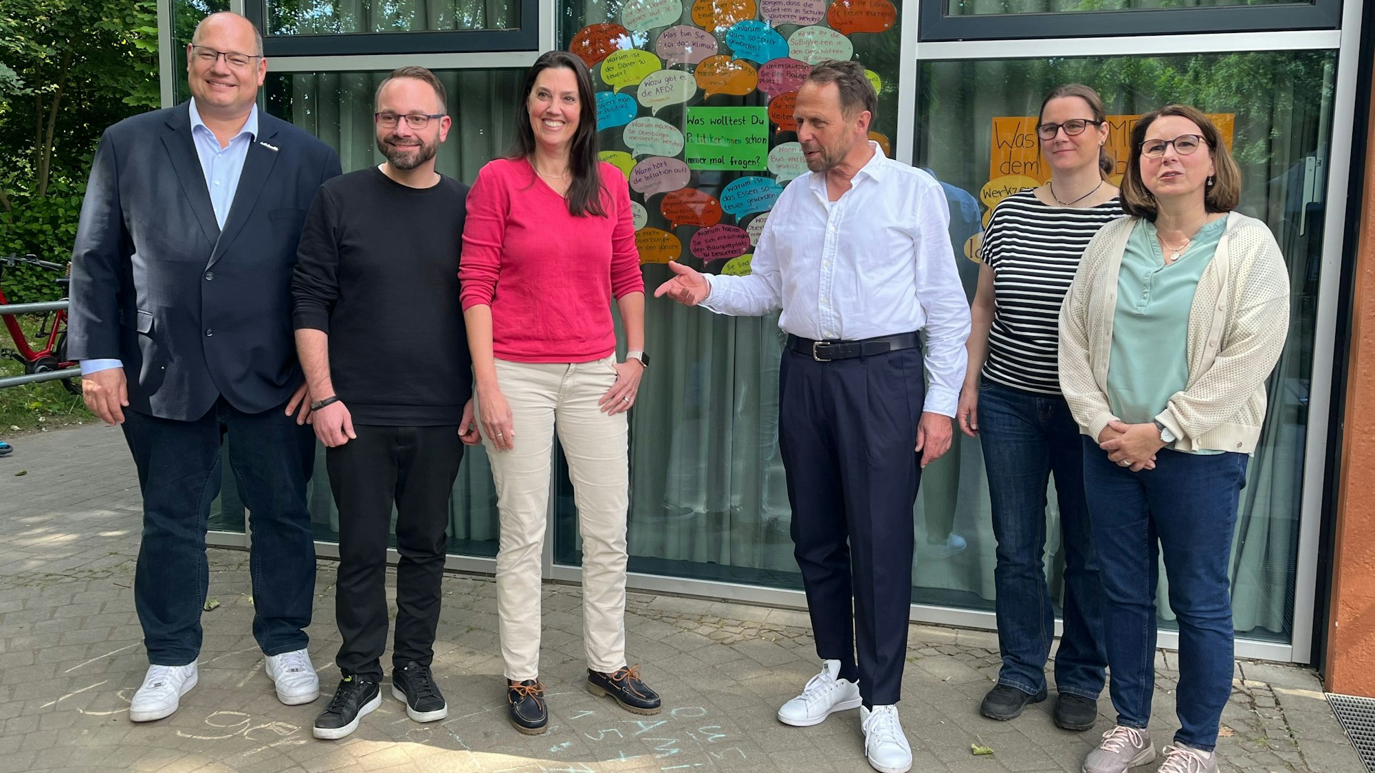 Politiker vor einer Fragewand.