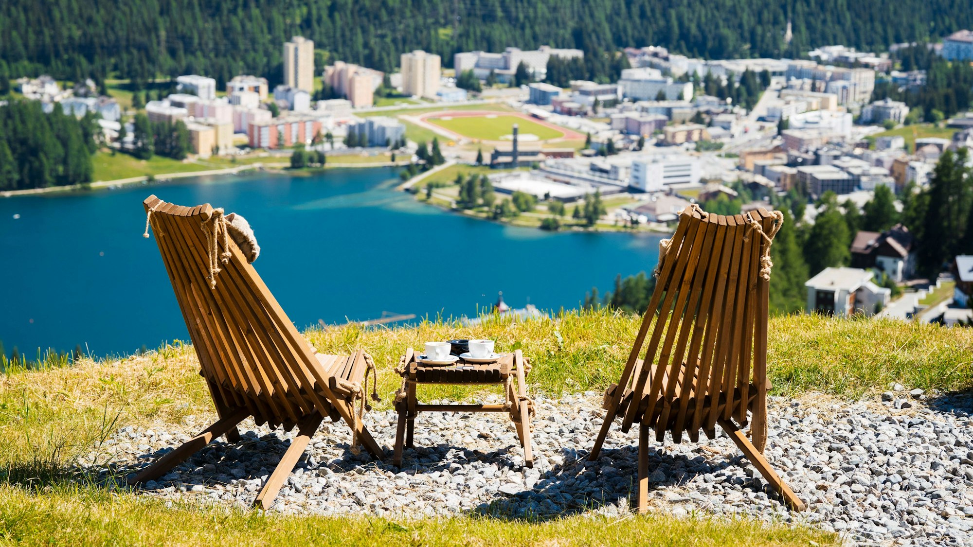Zwei hölzerne Stühle mit Blick auf die Berge der Schweiz.